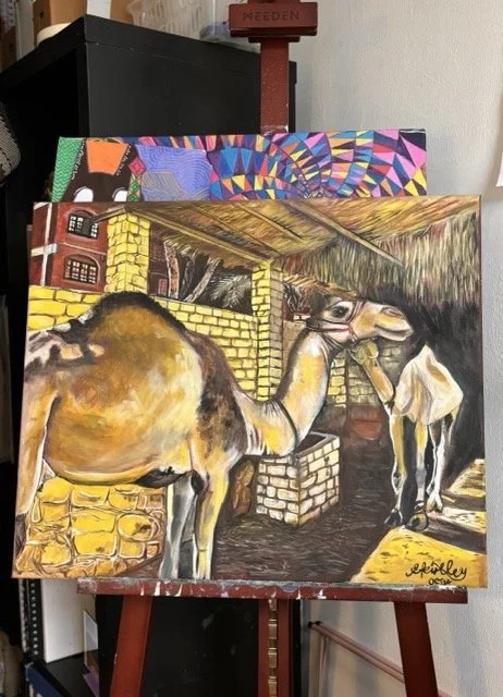 Painted canvas of a camel inside a stable with brick walls, with another camel in the background, signed by the artist Jeffrey.