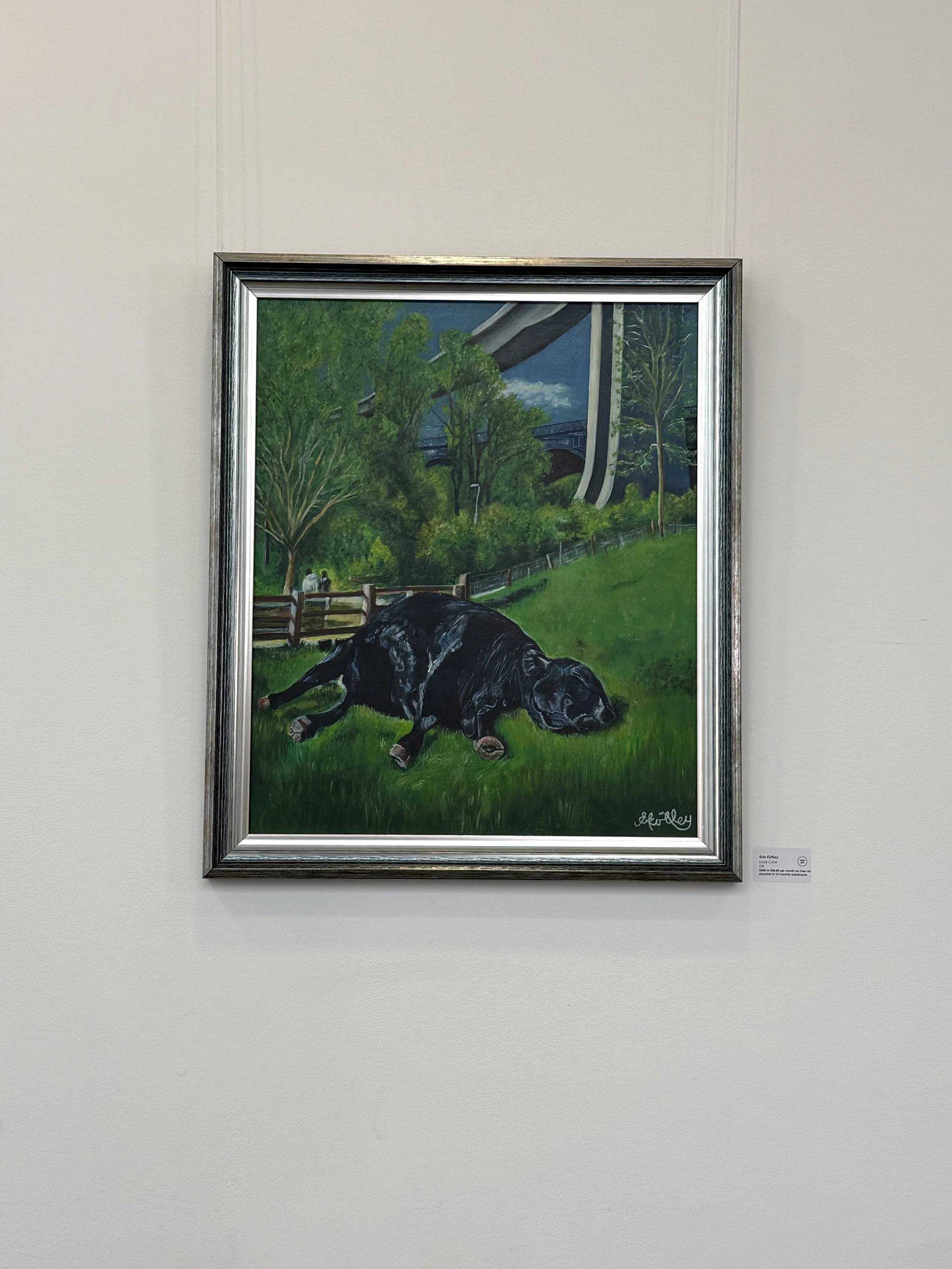 A painting of a dog lying on grass with trees and a bridge in the background, signed by the artist Lay Crook.