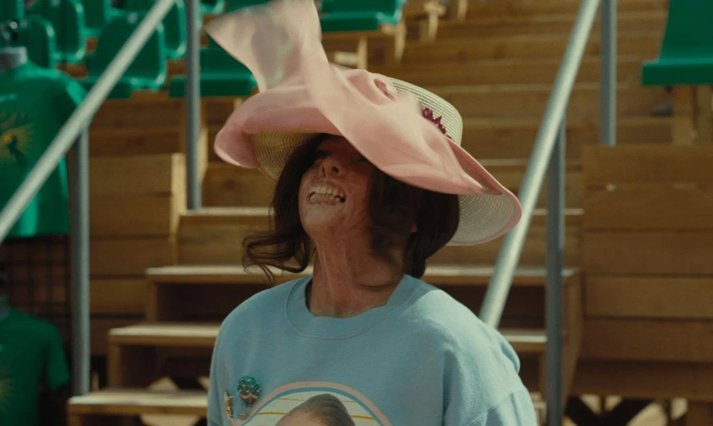 A woman's veil billows up, revealing that her face has been disfigured.