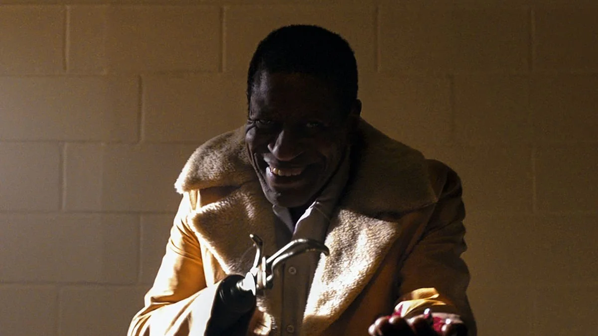 Image of Michael Hargrove as 2021's Candyman. With a hook in the place of one hand, he offers candy from the other.