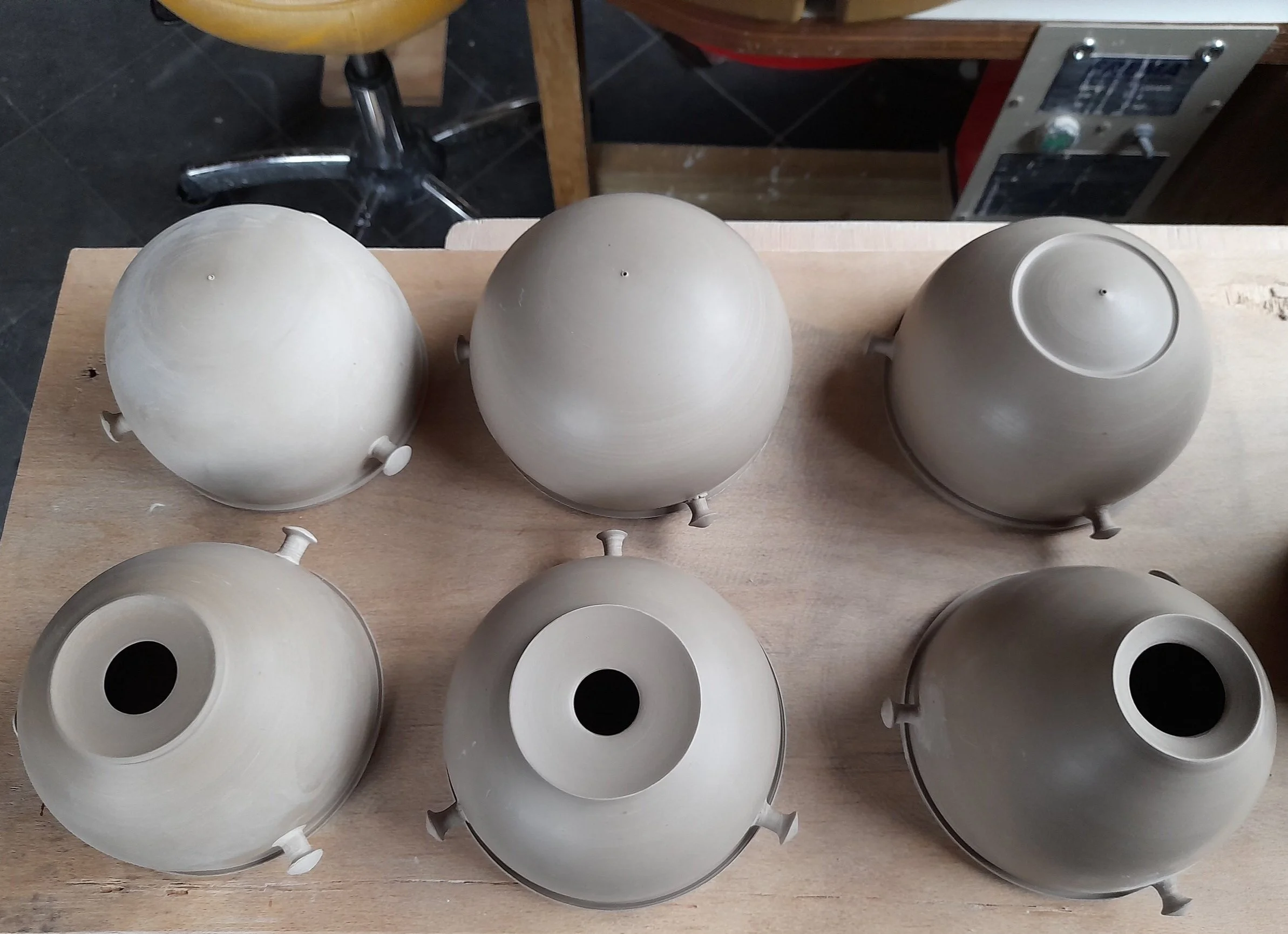 Unfired camera parts (top halfs). I made the body of the camera in two fitting halfs, thrown on the wheel. In earlier prototypes I made the pinhole directly in the clay (image top row), but for the finished piece I made a bigger hole (bottom row) in…