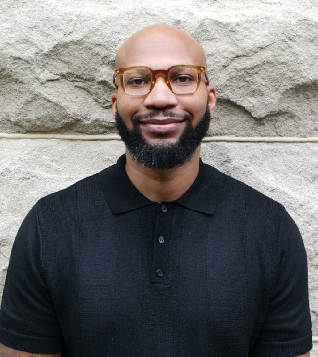 Jonathan Hall Headshot, standing in front of natural stone wall