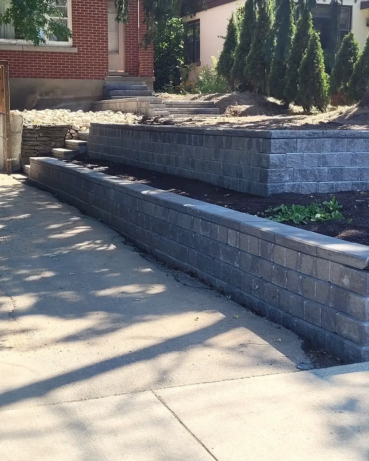Two-tier armour stone retaining wall by Brothers Landscaping using garden lock retaining wall stones in Kitchener, Ontario