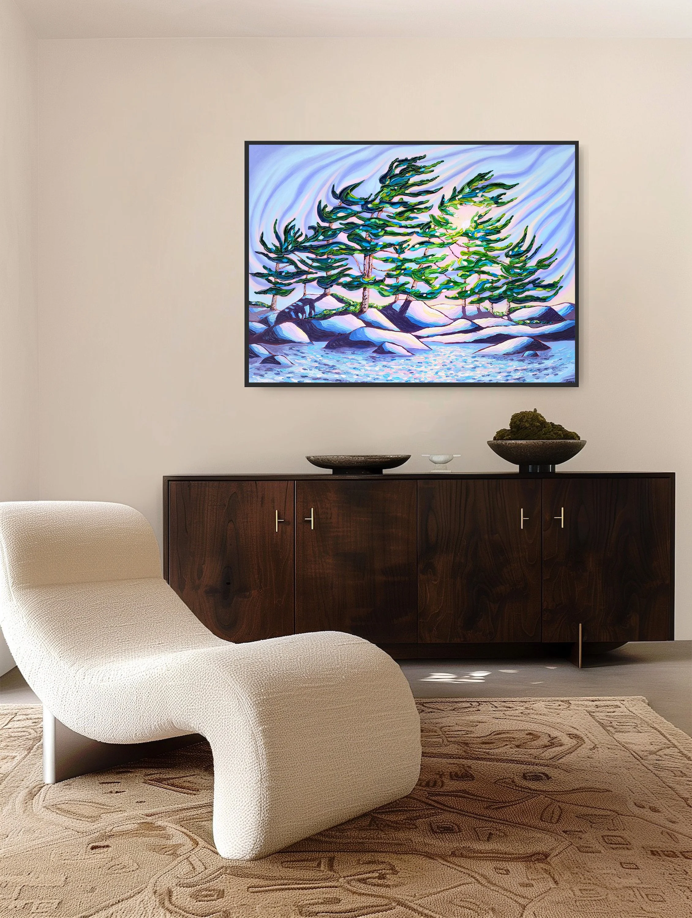 Living room with a modern white armchair, a dark wooden sideboard with decorative bowls and moss, and an abstract colorful painting of outdoor trees on the wall.