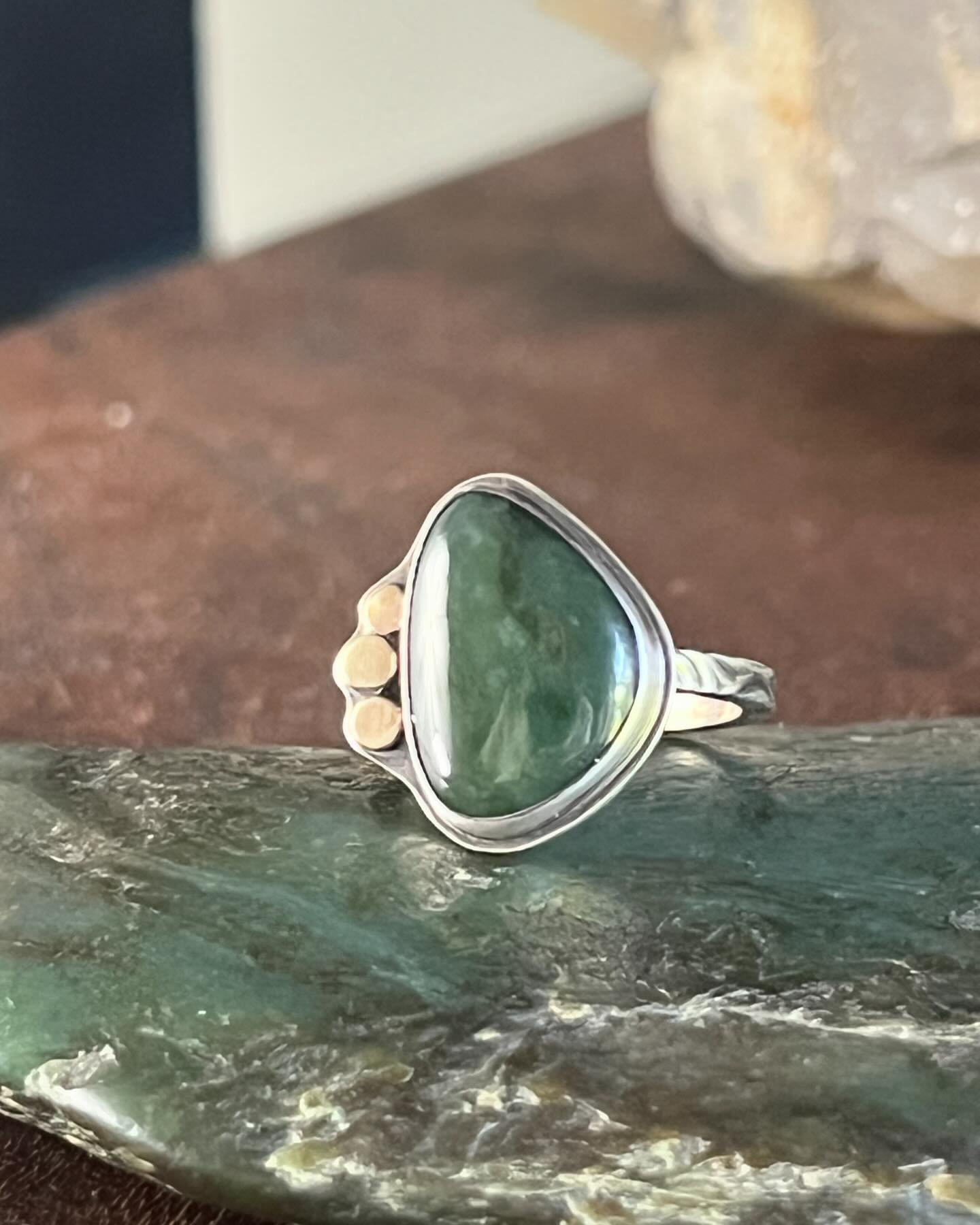 Presenting a size 8 sterling silver ring adorned with a magnificent Big Sur jade centerpiece, accentuated with luxurious 14k gold details. This striking piece captures the natural beauty of Big Sur jade, renowned for its rich, earthy tones and unique