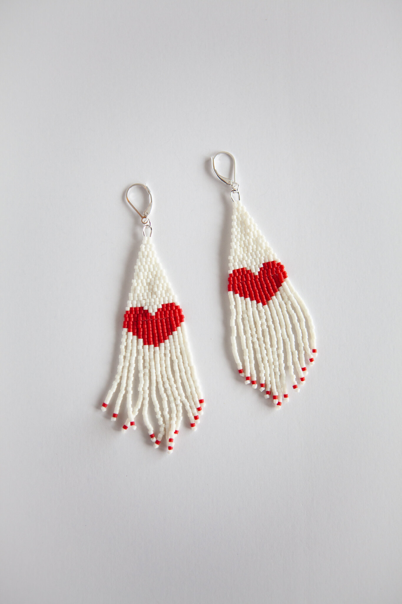 White beaded earrings with red hearts inlayed