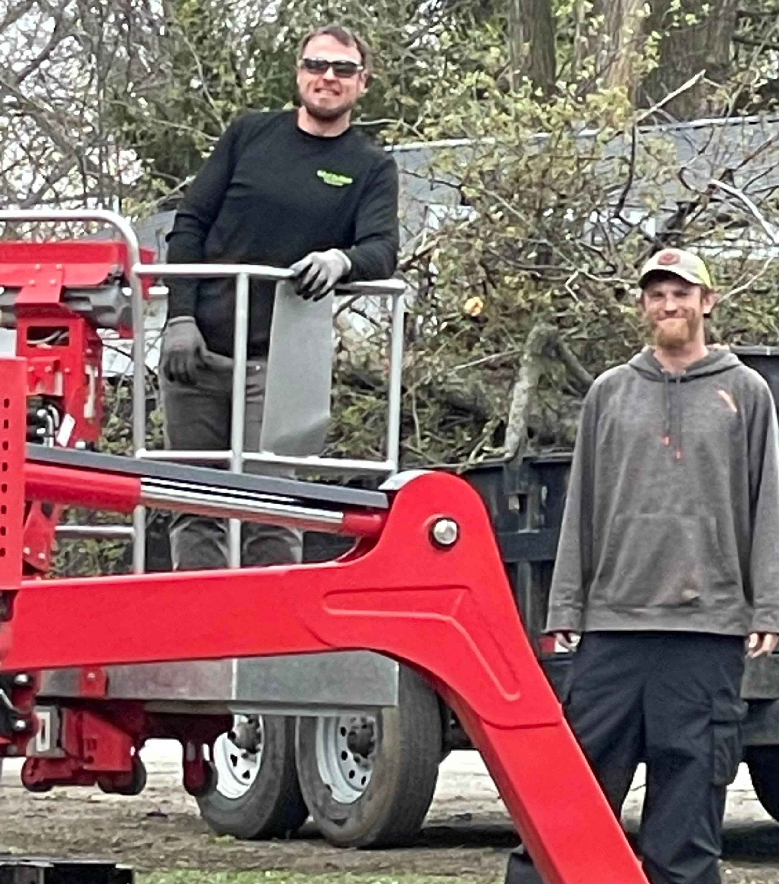 Two bull of the woods team members posing by equipment