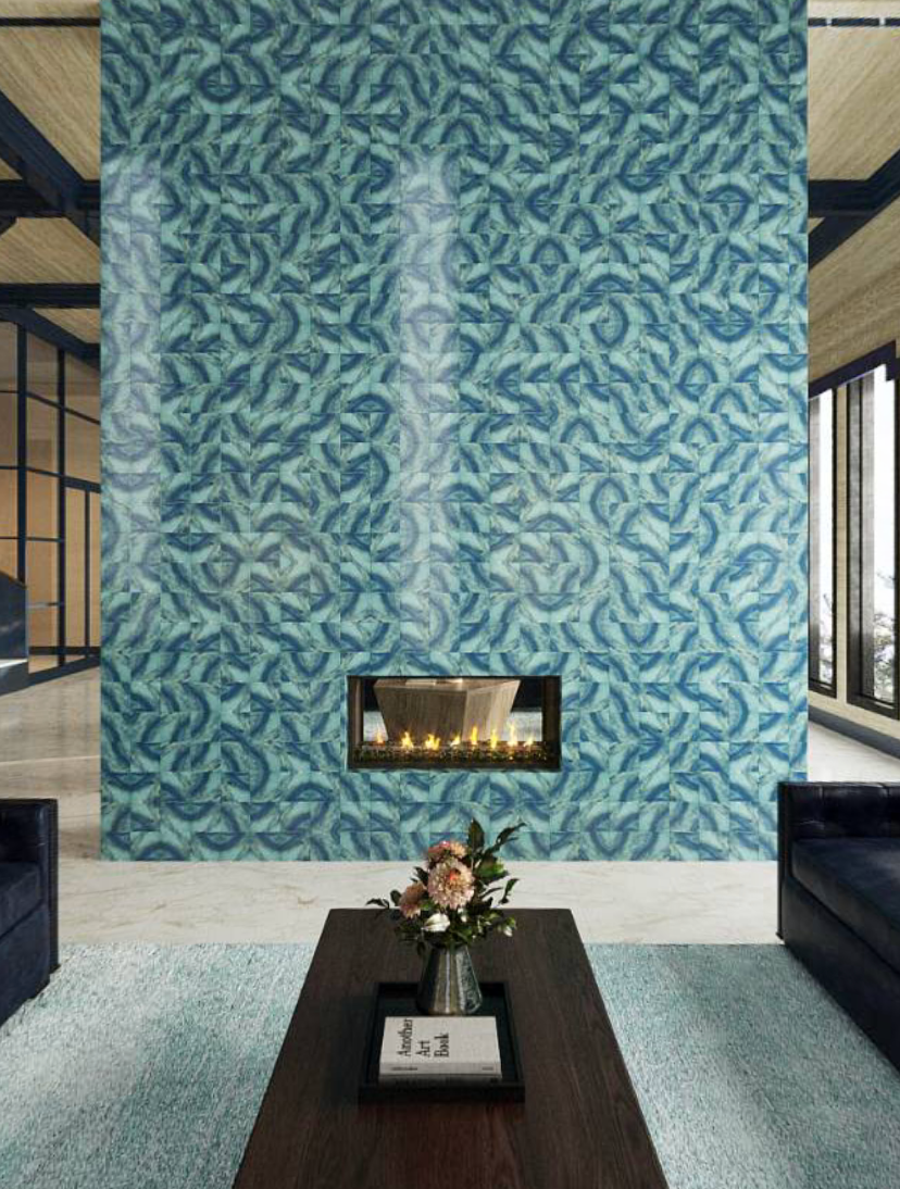 Interior of a modern living room with a tall blue patterned wall, a fireplace, a wooden coffee table with a flower arrangement, and black sofas.