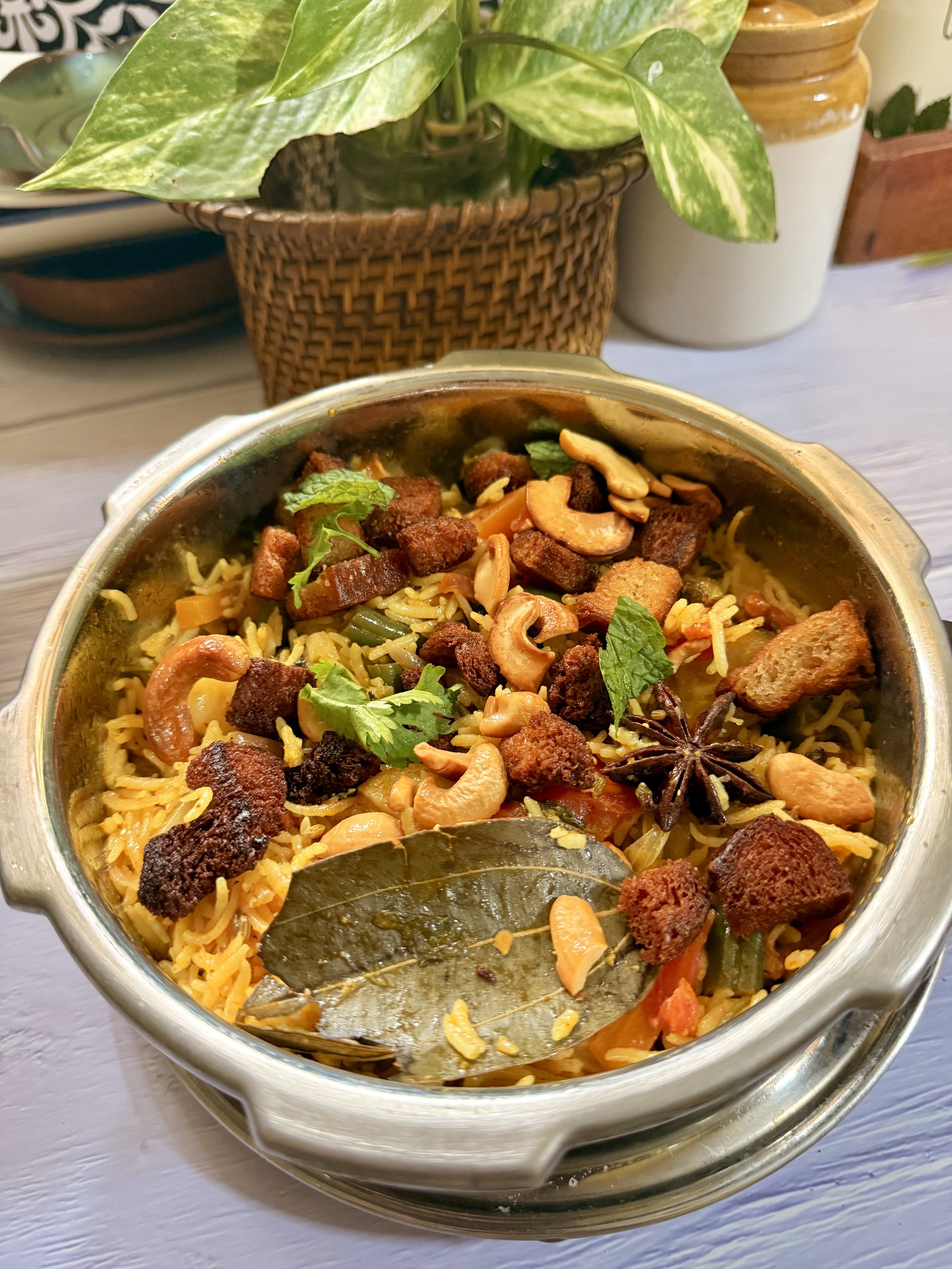 South Indian Brinji rice garnished with fried onions and mint in a steel pot
