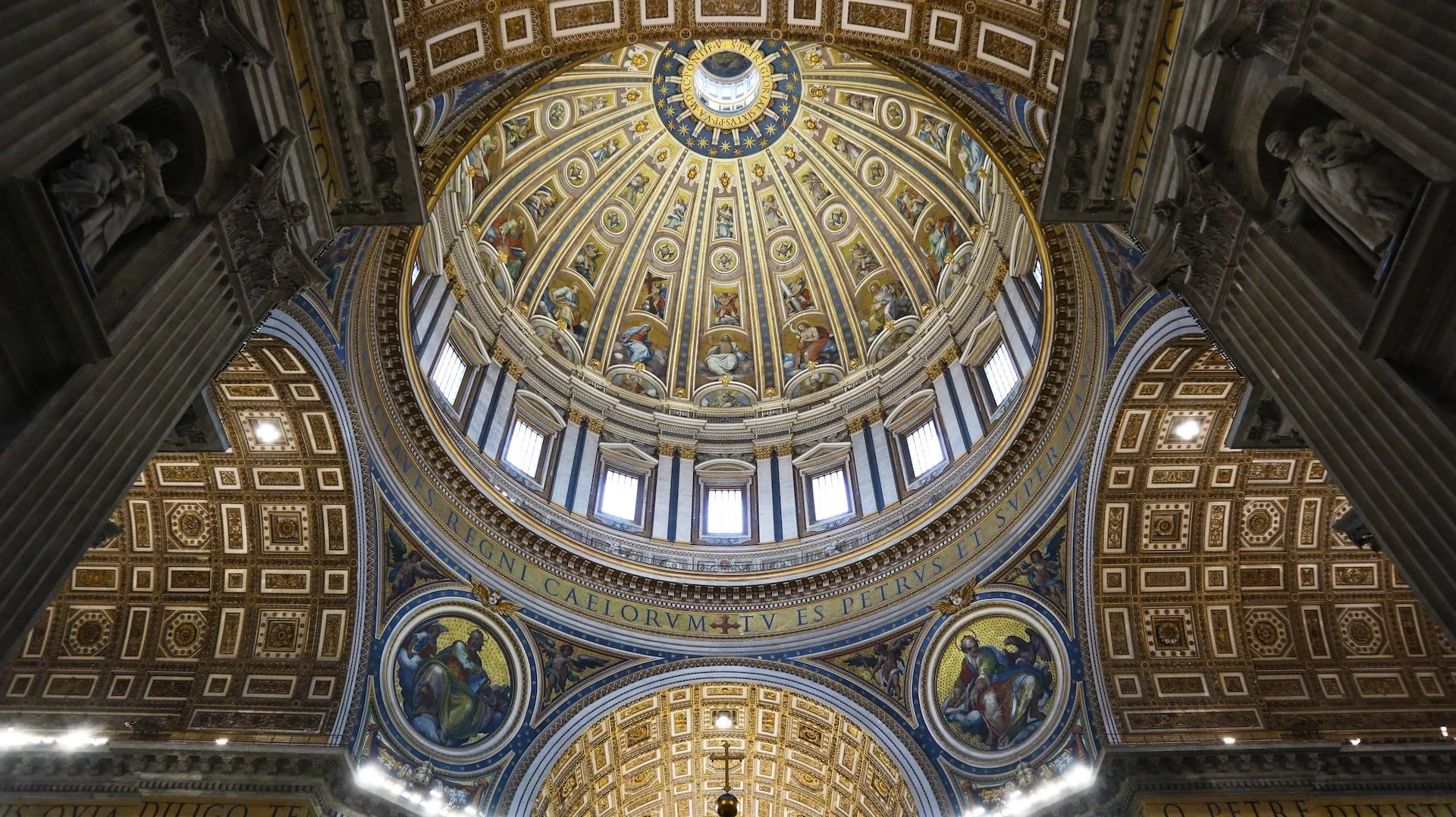 Interior of the ornate dome of St. Peter’s Basilica in Vatican City, viewed from below.