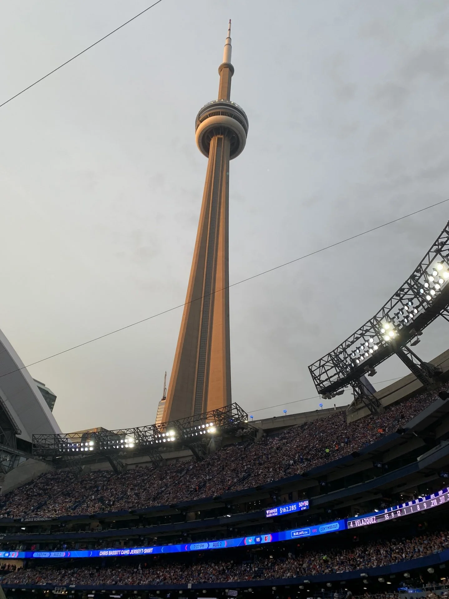 CN Tower seen above the open roof and stadium seating at Rogers Centre.