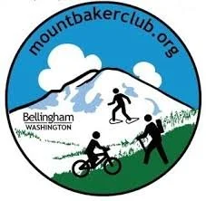 Logo for Mount Baker Club featuring silhouettes of a hiker, cyclist, and snowshoer with Mount Baker in the background. Text reads "mountbakerclub.org" and "Bellingham, Washington."
