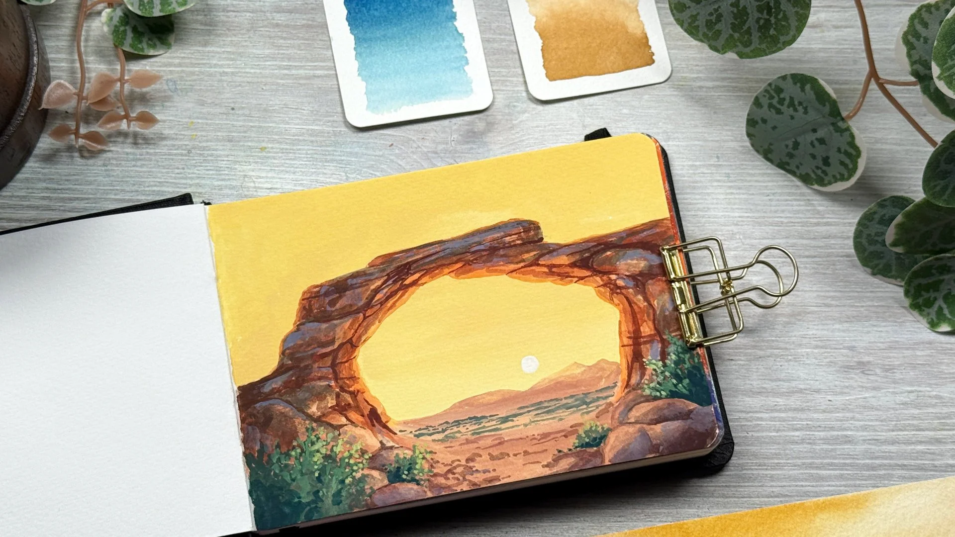 A gouache painting of a warm golden glow on a rock arch