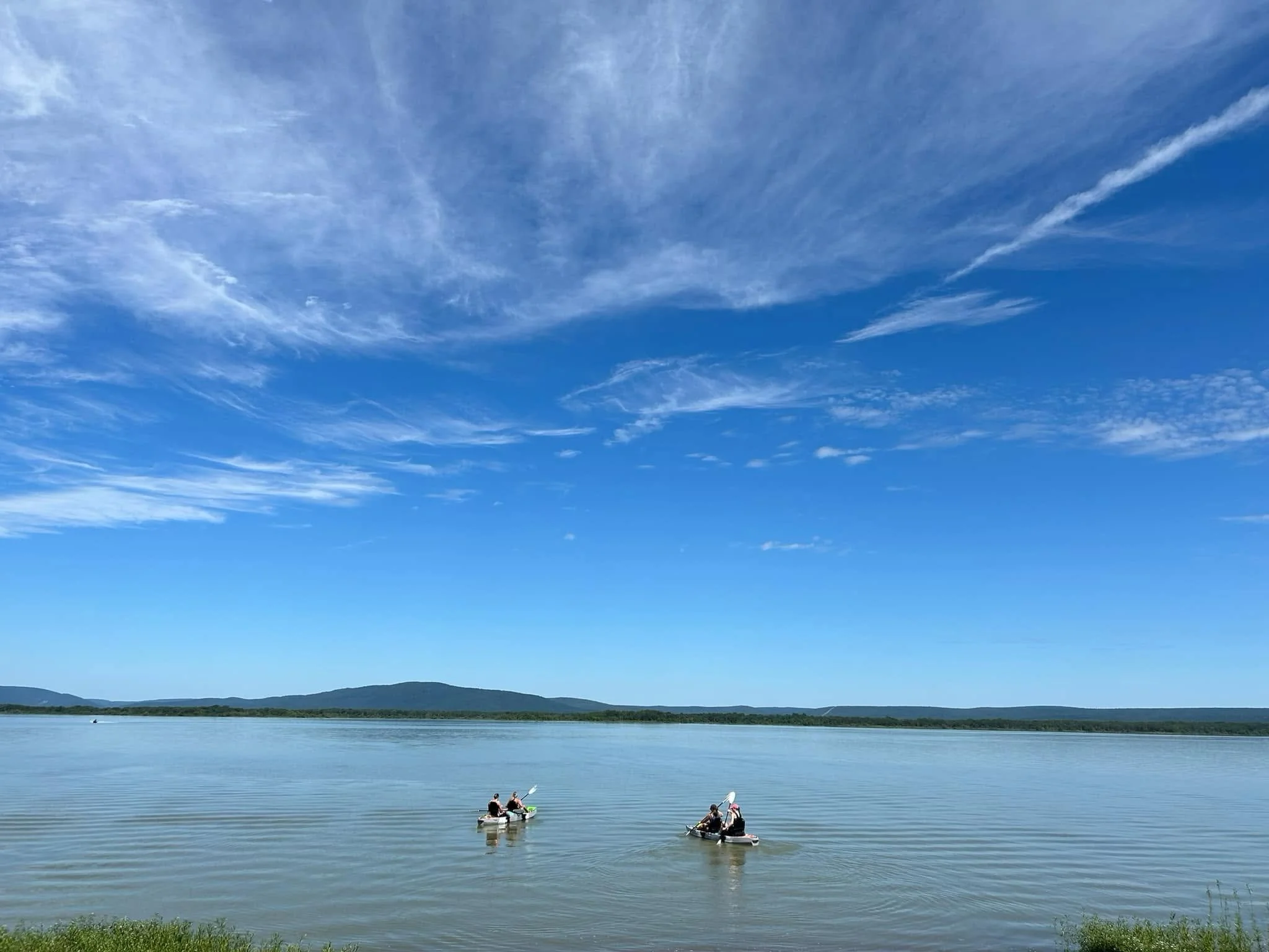 Visitors kayaking on Sardis Lake in Oklahoma beneath a clear blue sky.