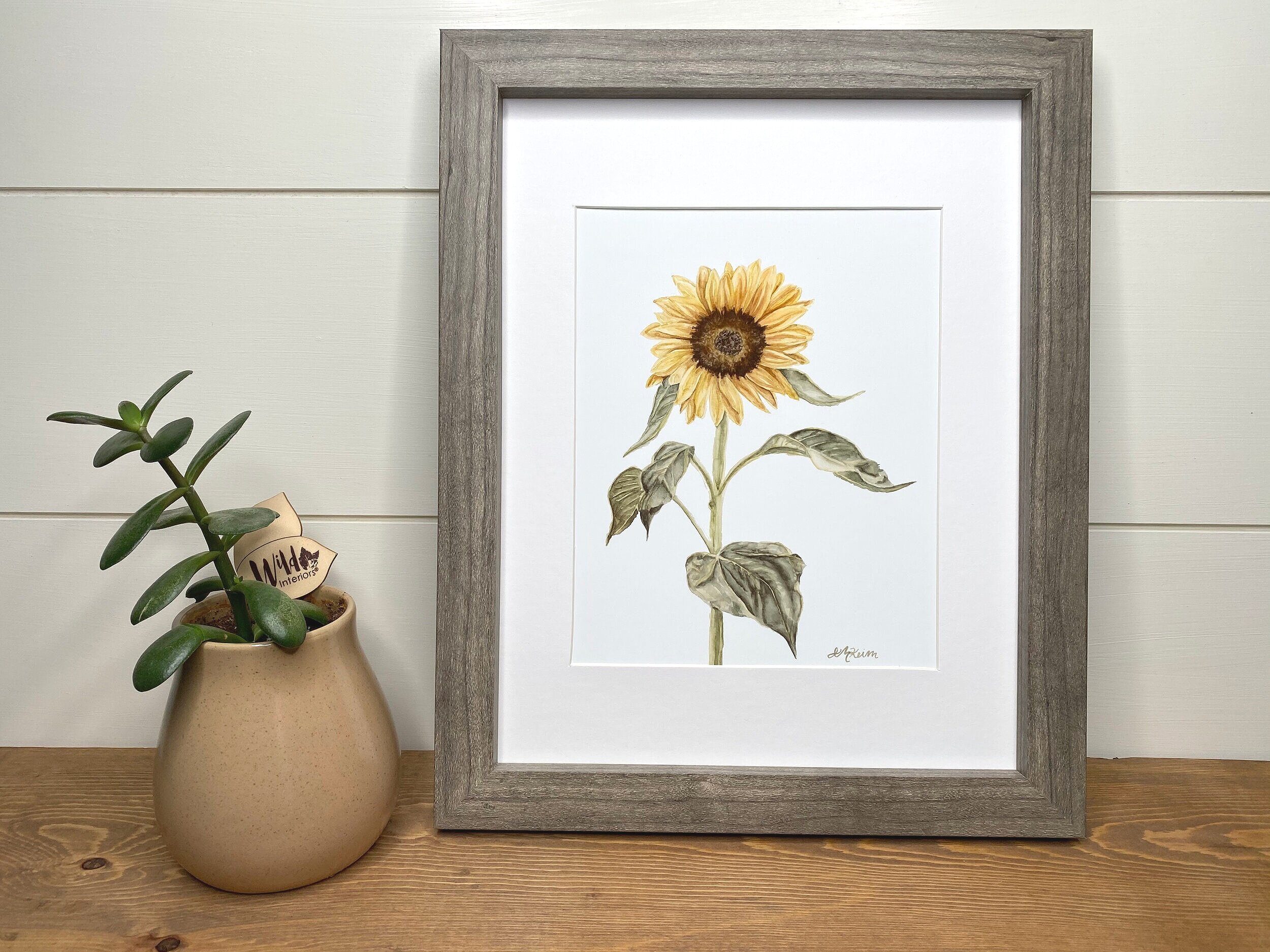 framed watercolor sunflower print on decorative shelf