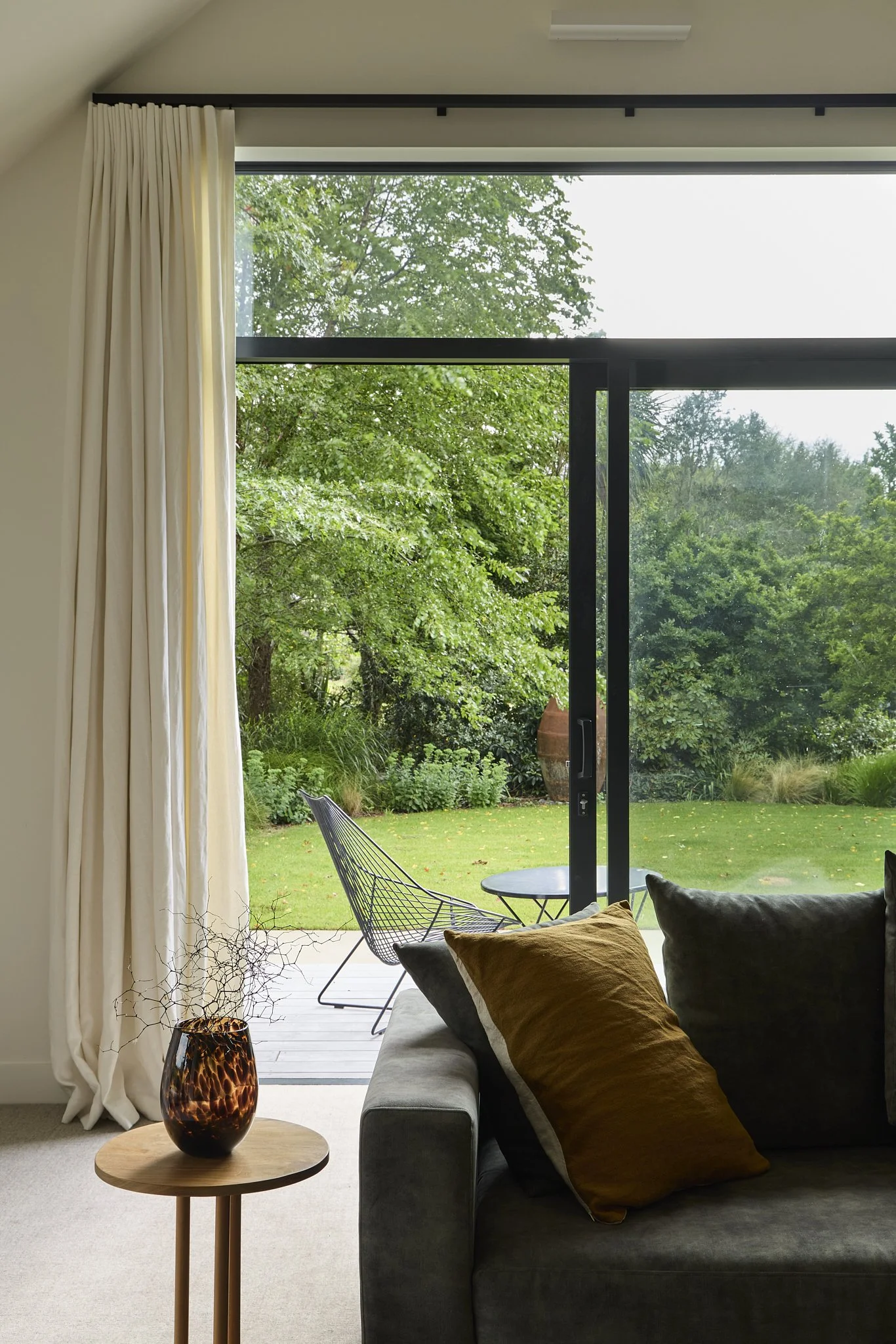 Light-filled living room with large doors and pond views