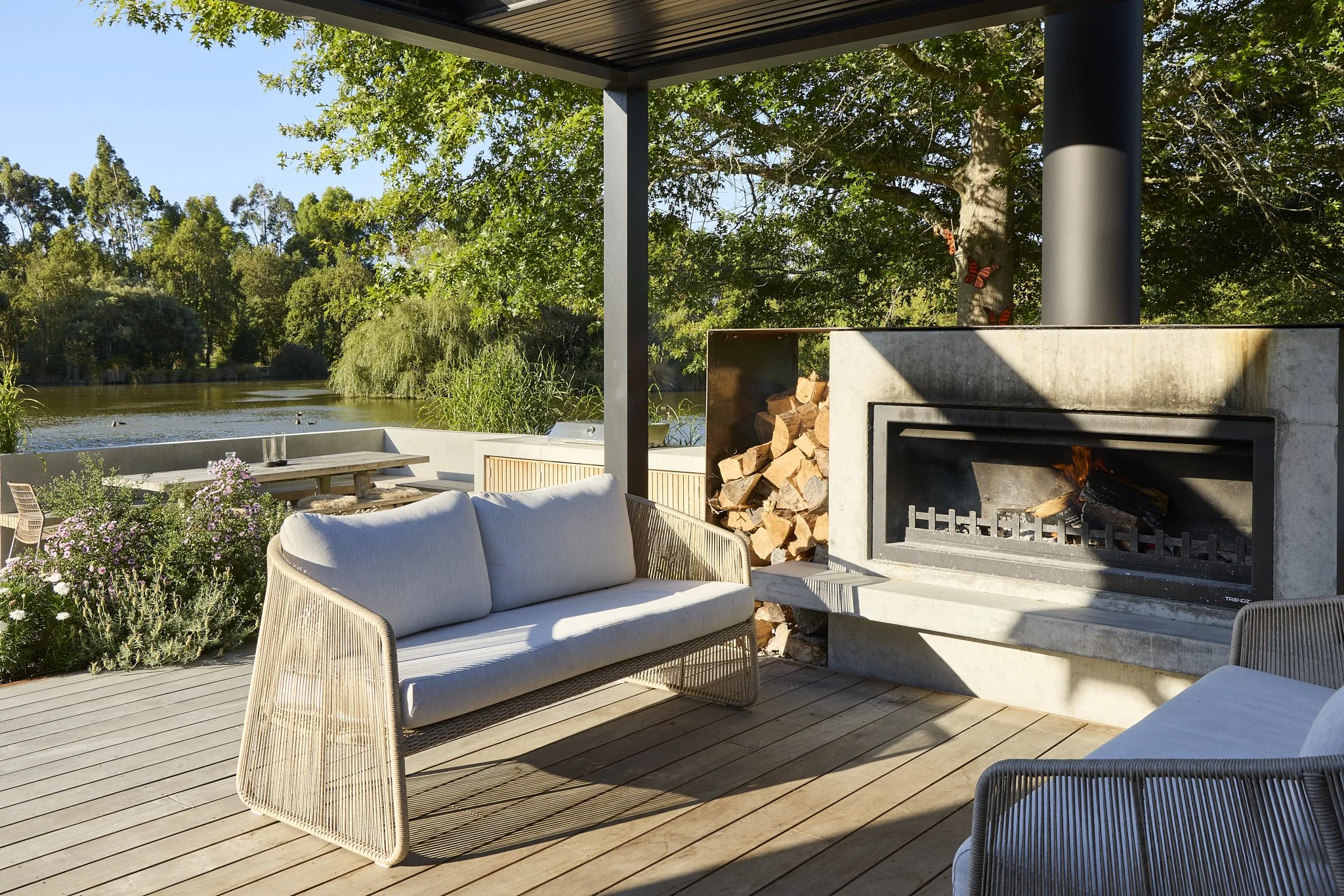 Covered outdoor entertaining area with fireplace and pond outlook