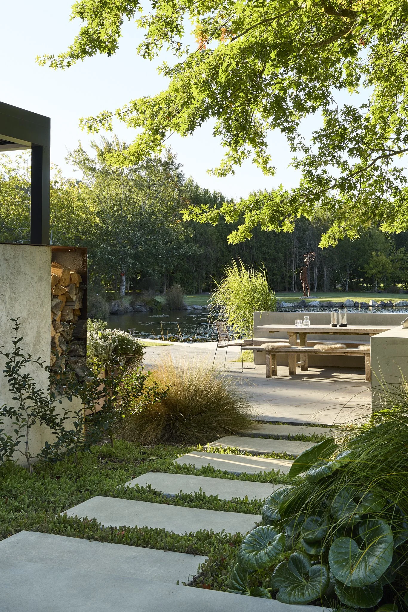 Covered outdoor entertaining area with fireplace and pond outlook