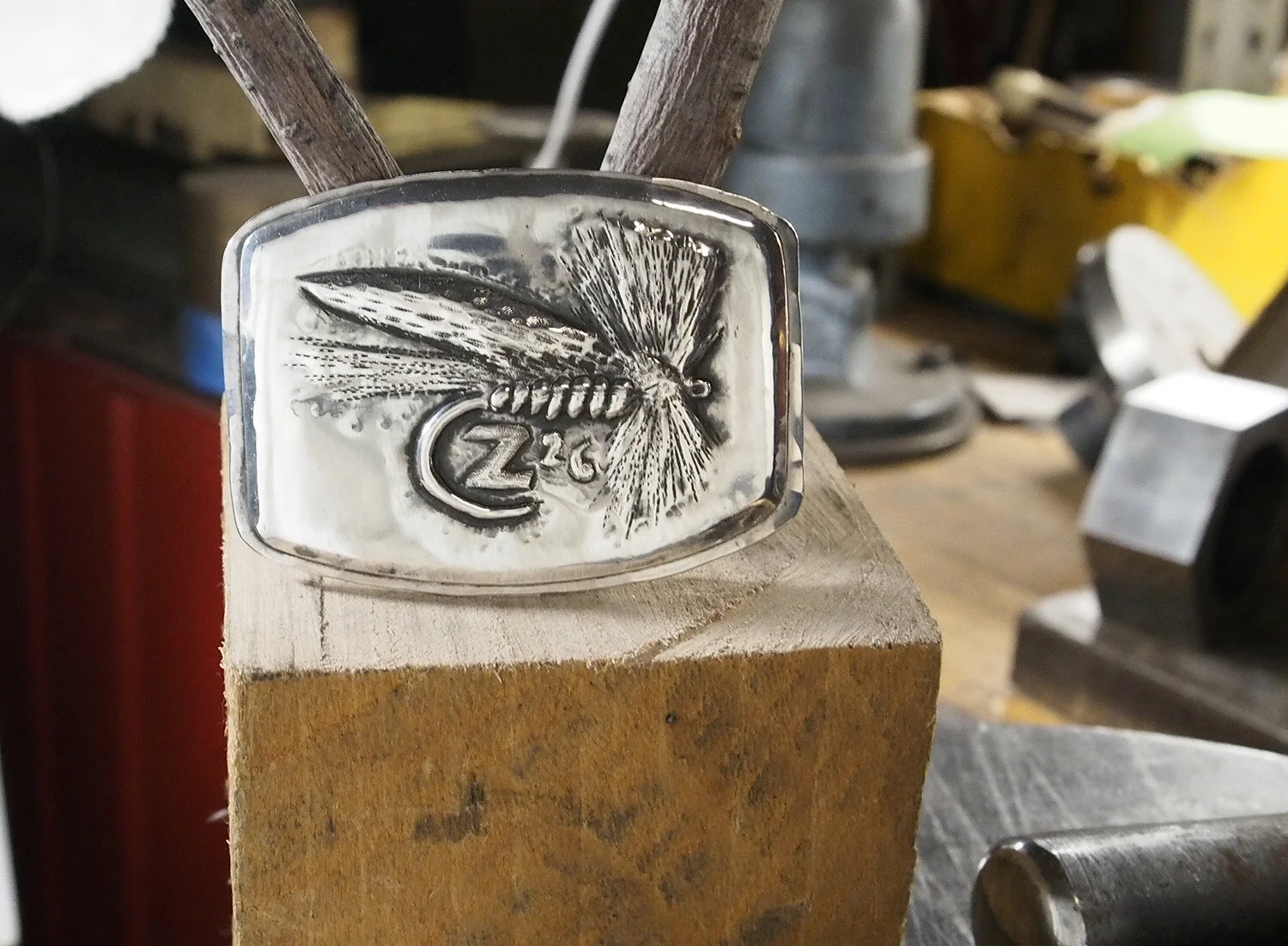 Commemorative dry fly buckle in the "plaque" style. The entire front of the buckle is a piece of sterling - which is mounted to a sterling hybrid shaped belt buckle. Three inches wide.