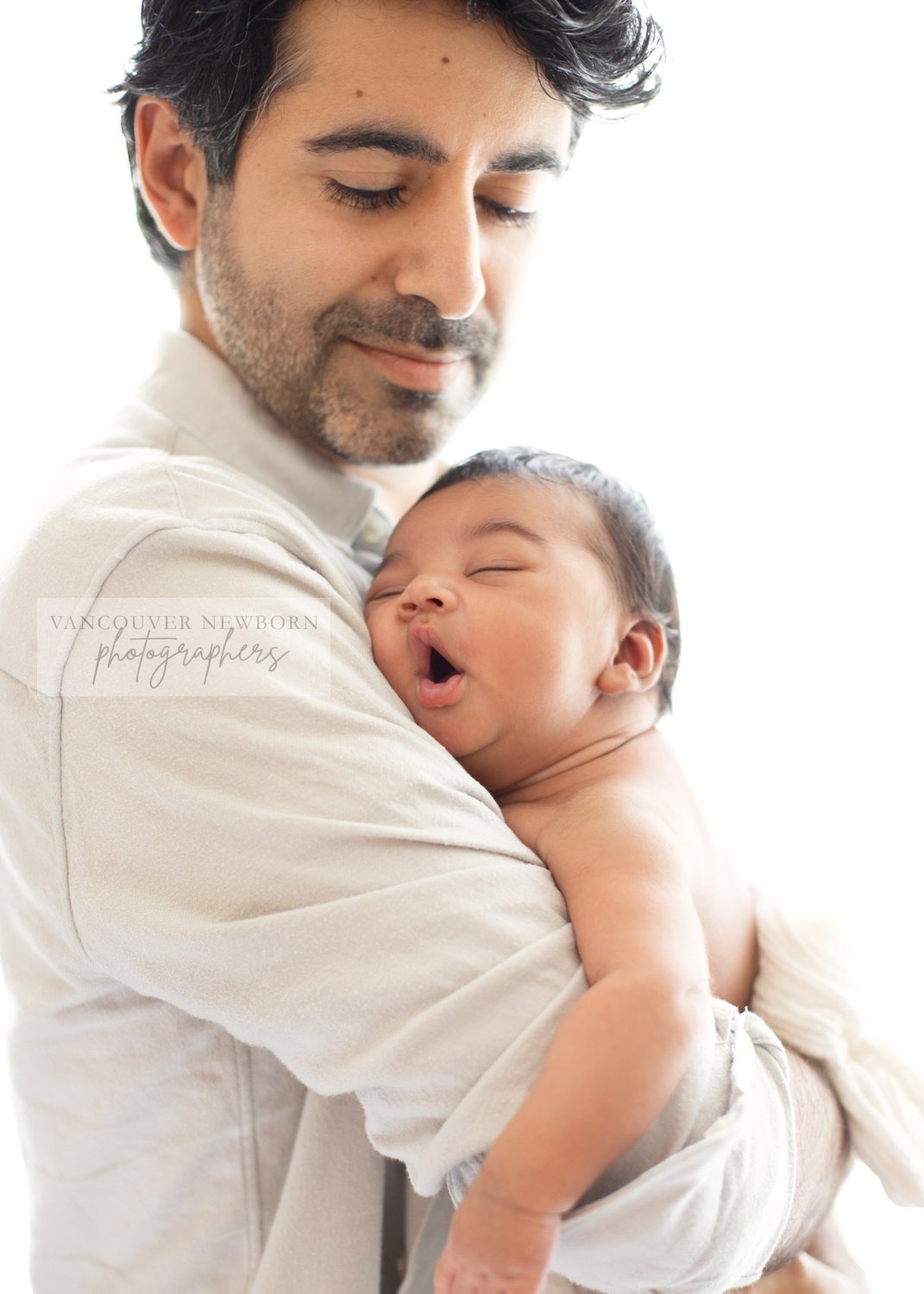 Dad holding sleeping newborn