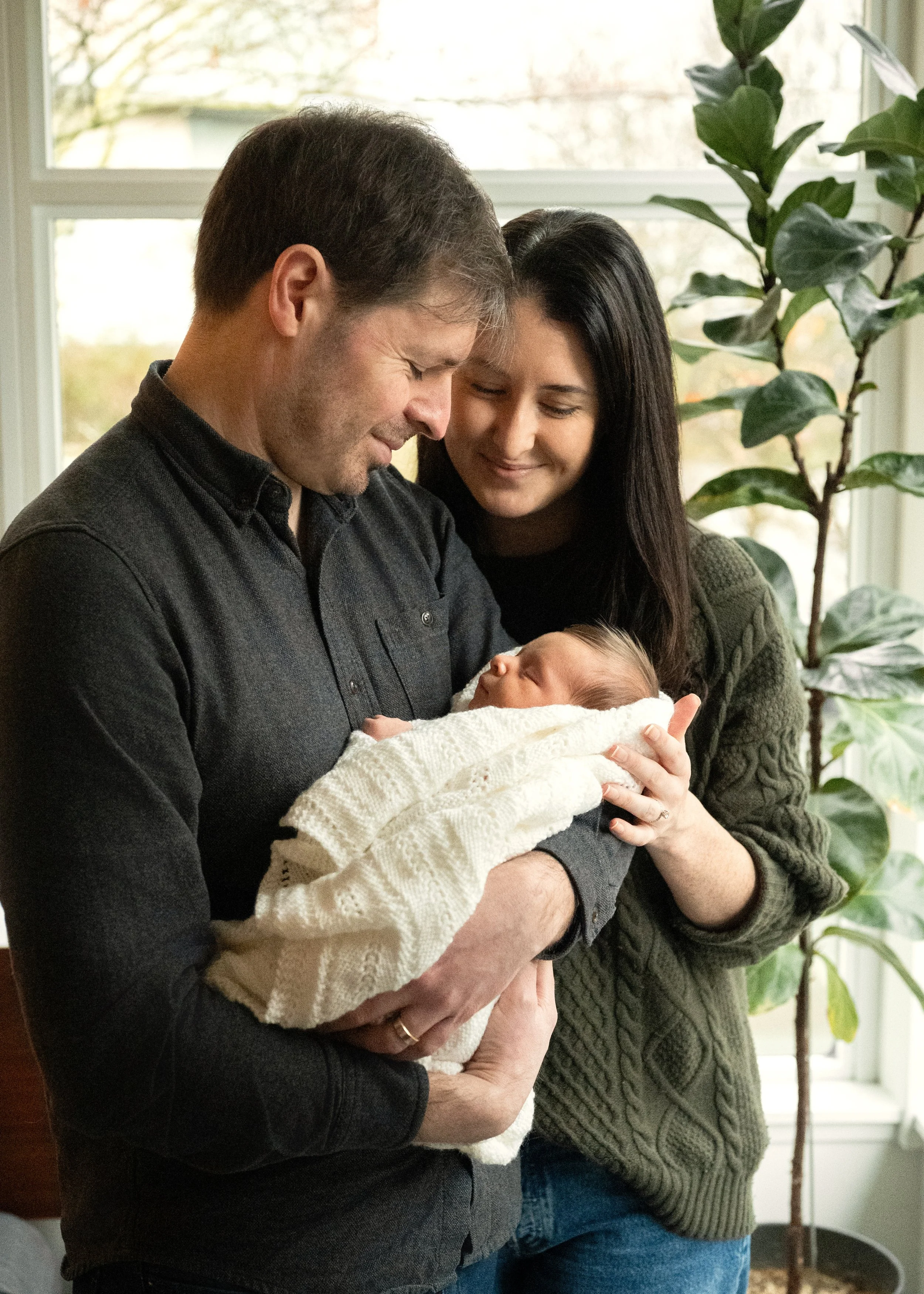 Lifestyle newborn session at home with baby and parents captured by Vancouver Newborn Photographers