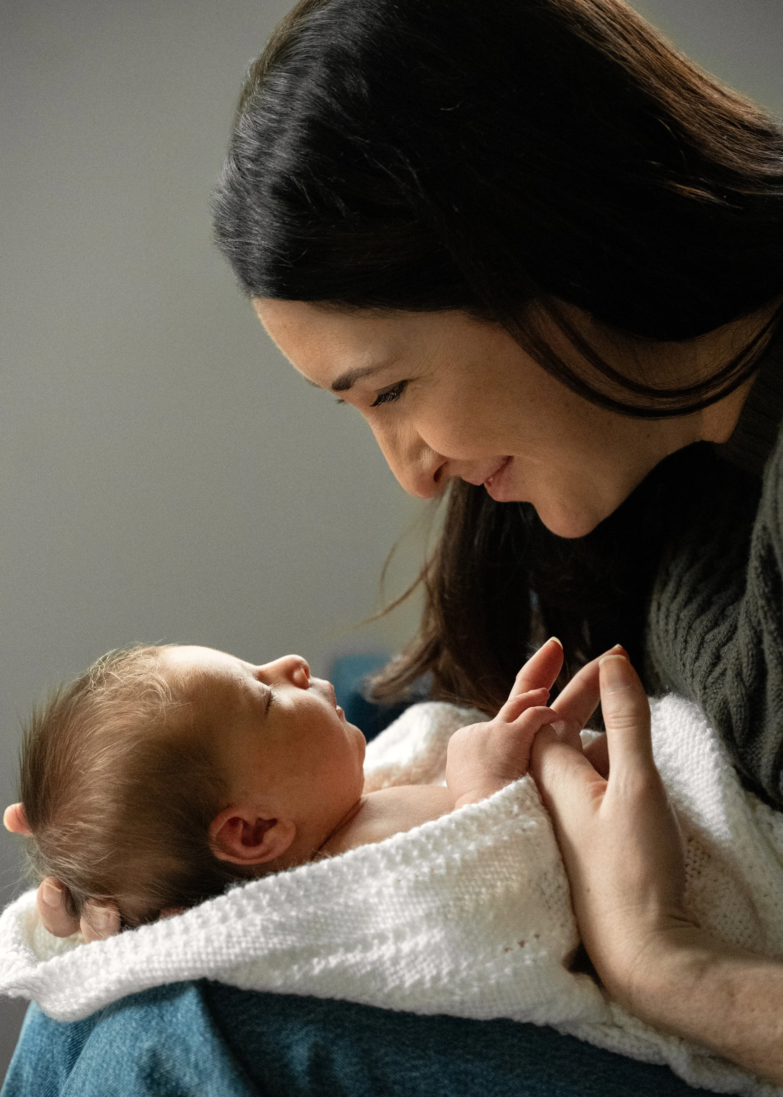 Mom looking down tenderly at newborn baby