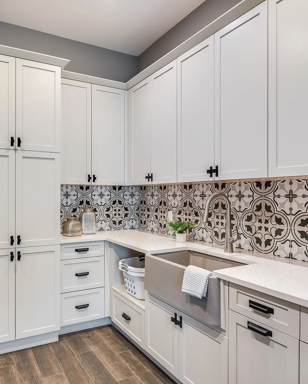 Grounded in natural tones, this laundry room proves that even the most functional spaces can be elevated with thoughtful design. With abundant storage, generous countertops for easy folding and wrapping gifts, and a patterned backsplash that adds jus