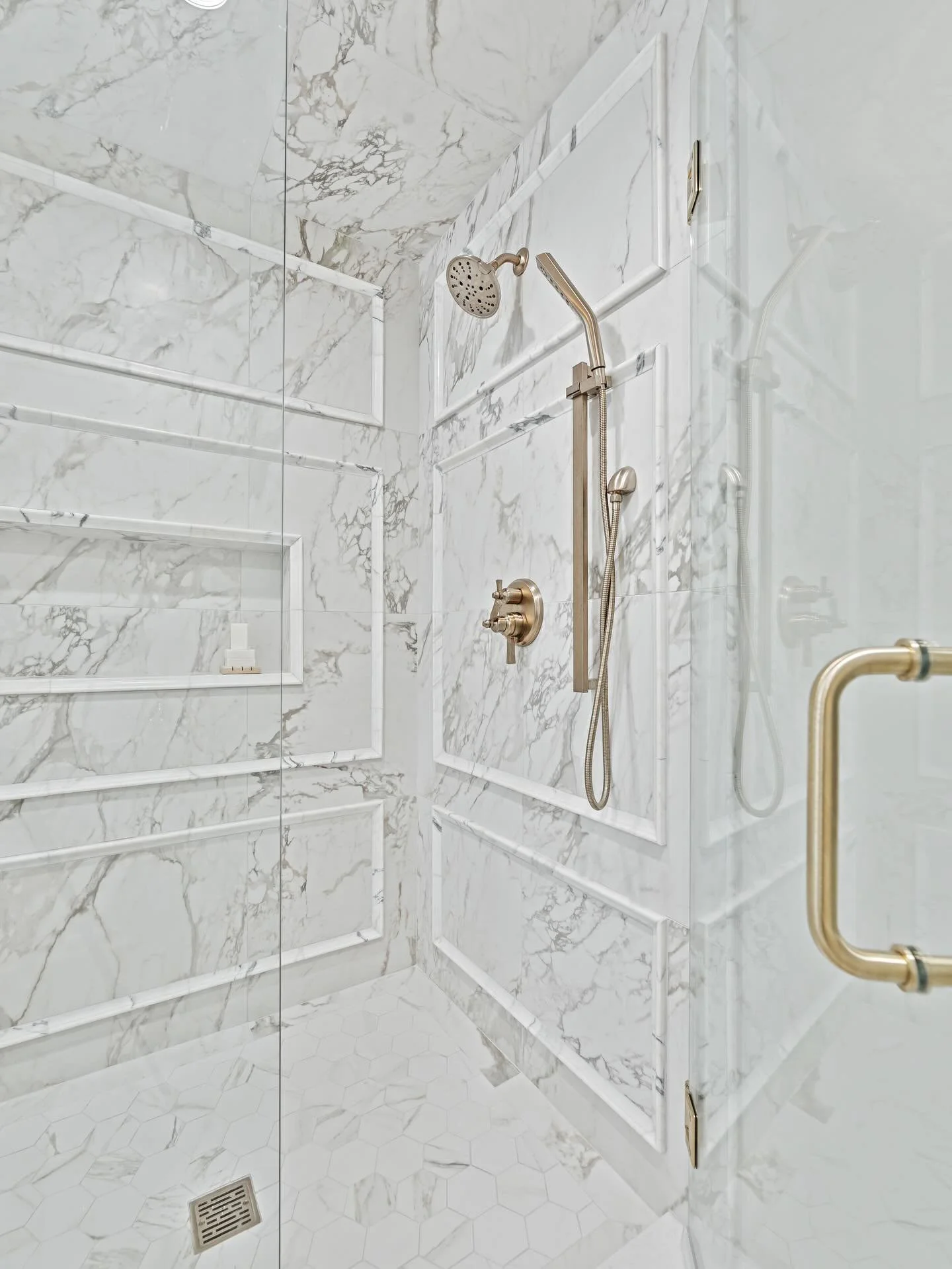 This shower took a lot of math, a few site visits, and the hands of an incredible tile setter, and every bit of it was worth it.

A custom mix of porcelain and marble, layered in soft whites with subtle gray veining, creates a tone-on-tone moment tha