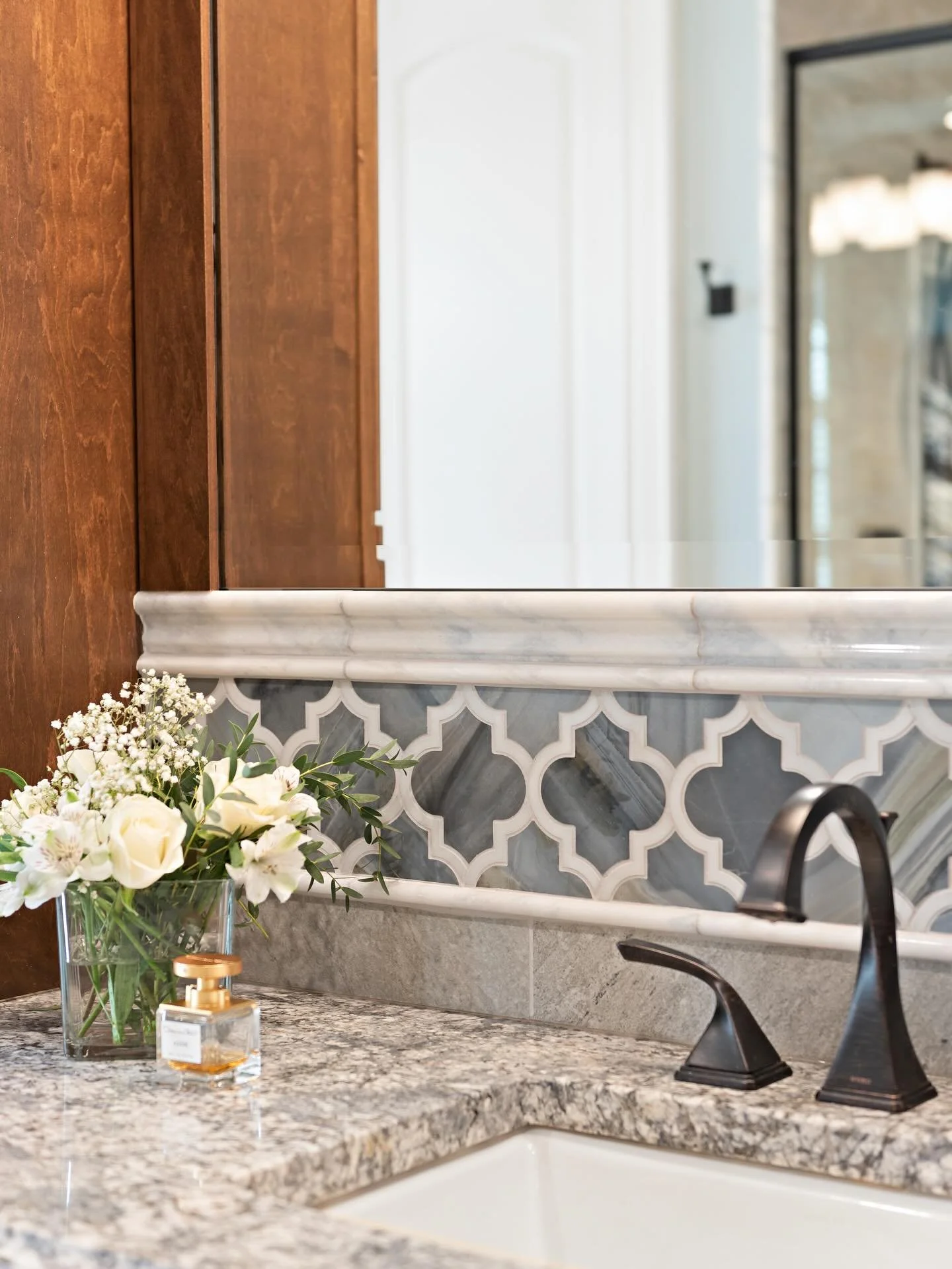 Fresh from post-processing, the primary suite at our custom build project is all about the details, layered porcelain, marble, and granite working together in the most timeless way.

From the decorative vanity backsplash to the custom shower niches a