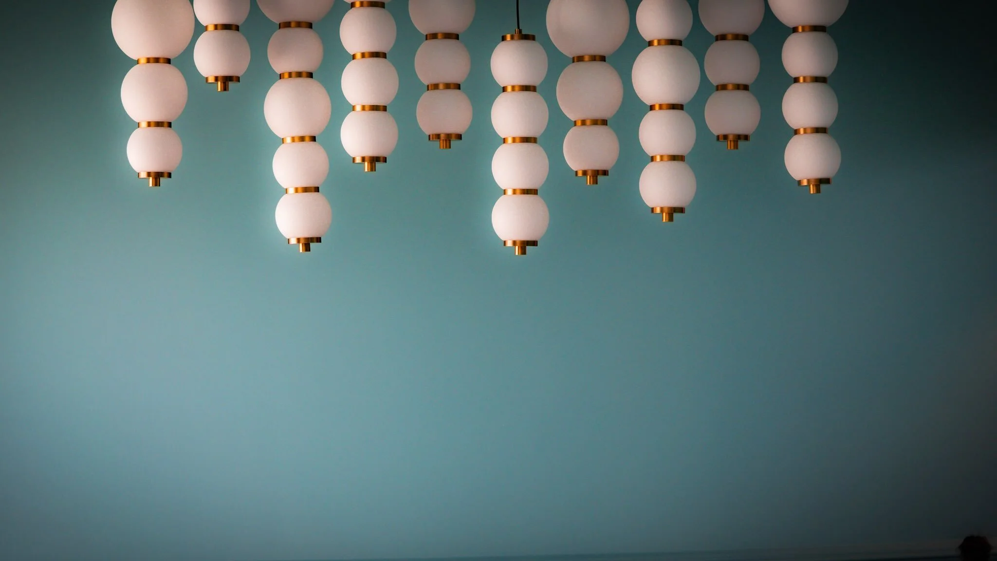 Lighting is the jewelry of a room, and we love selecting that one special piece that makes a statement and completes the space beautifully.

This sculptural chandelier feels like a work of art against the rich blue green walls, adding warmth, movemen