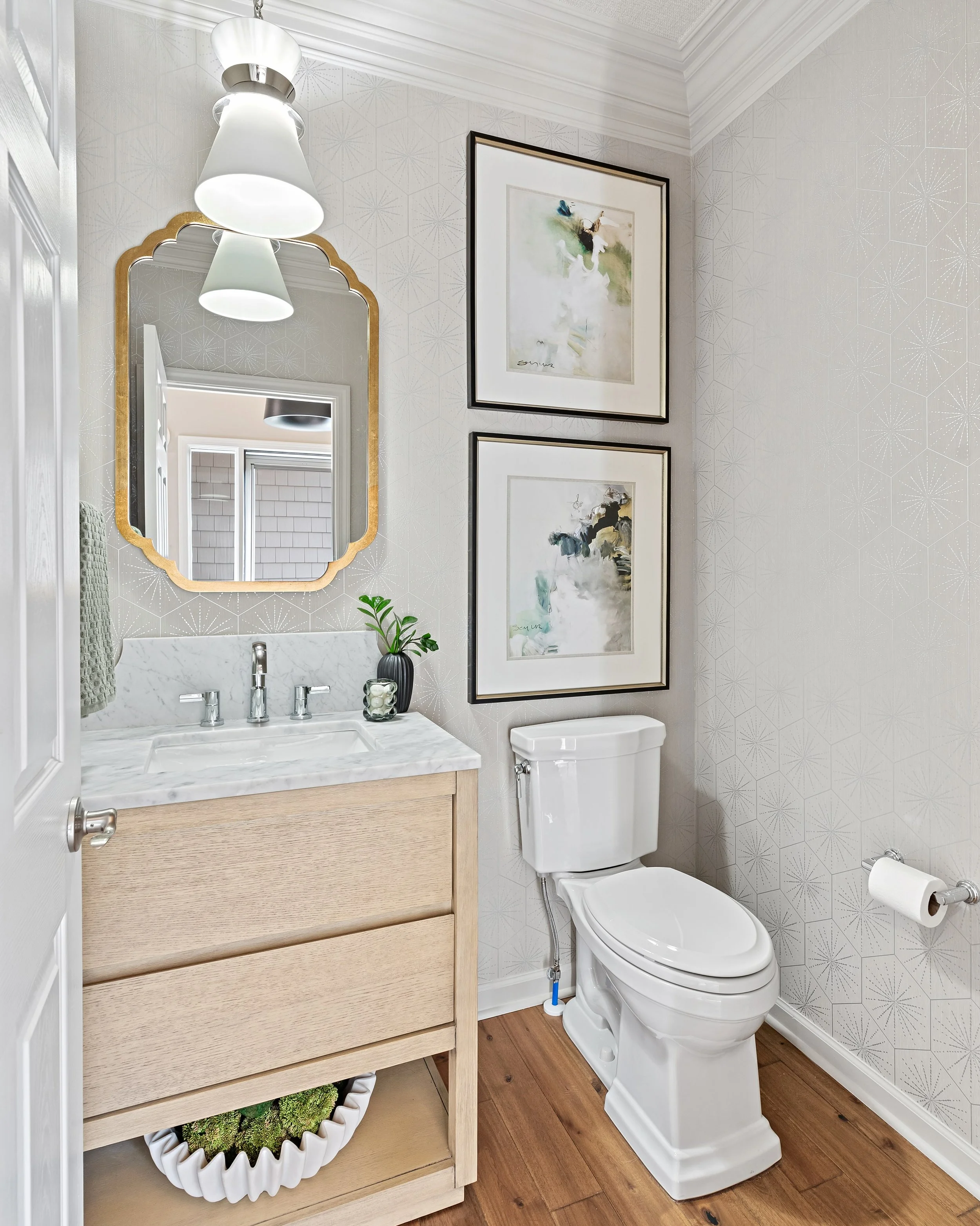 I love a light and bright space with a little character. In this powder room, patterned wallpaper, a marble backsplash with a scalloped edge, a mix of metals, and a statement light bring together all the details I love. Bonus points for the beautiful