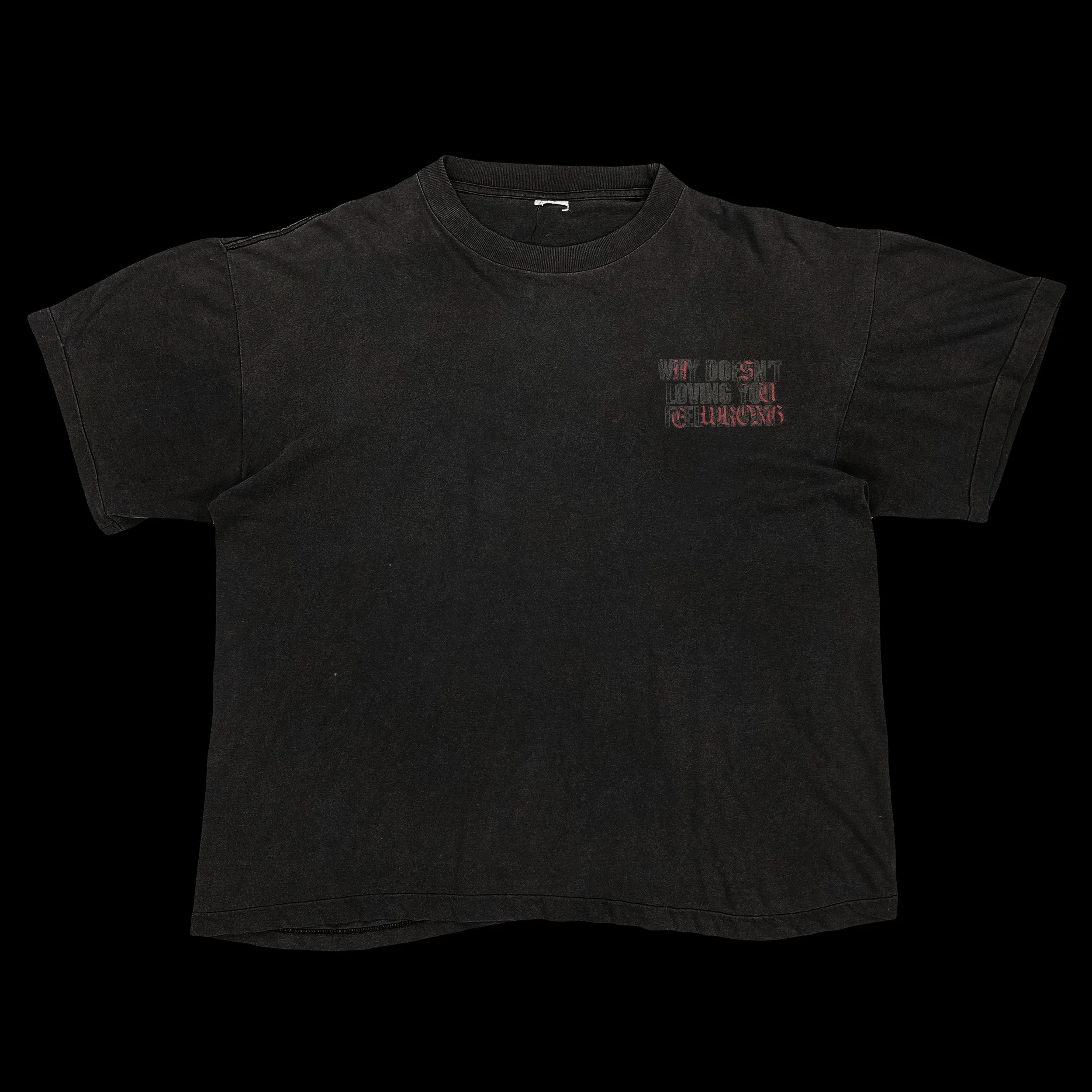 A black T-shirt with small red and gray text on the upper left chest area, displayed on a black background.