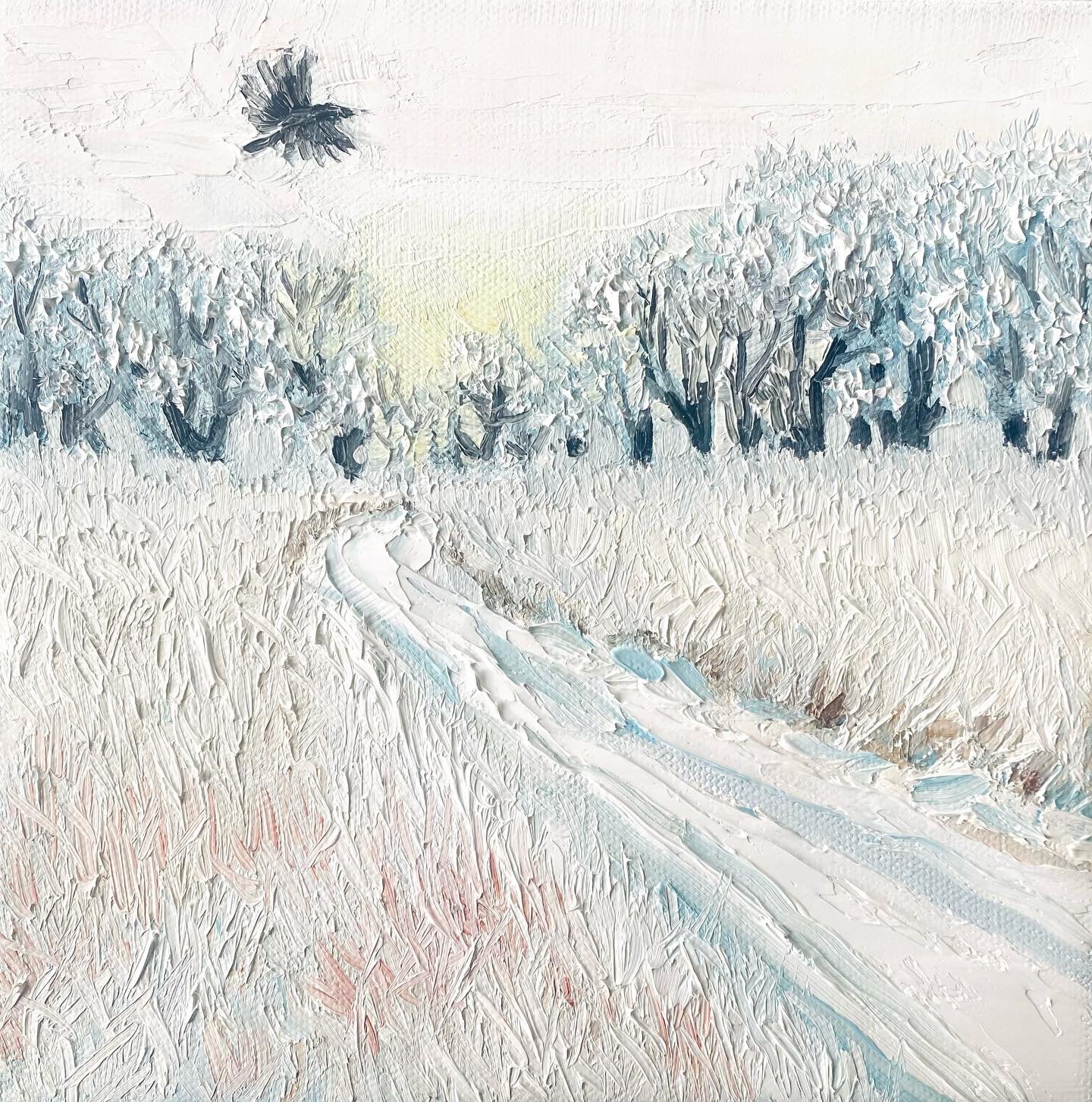 A solitary blackbird soars gracefully over a pristine, snow-covered landscape, its dark wings cutting through the crisp, winter air. Below, the ground is blanketed in a thick layer of white, the stillness of the scene broken only by the bird&rsquo;s 