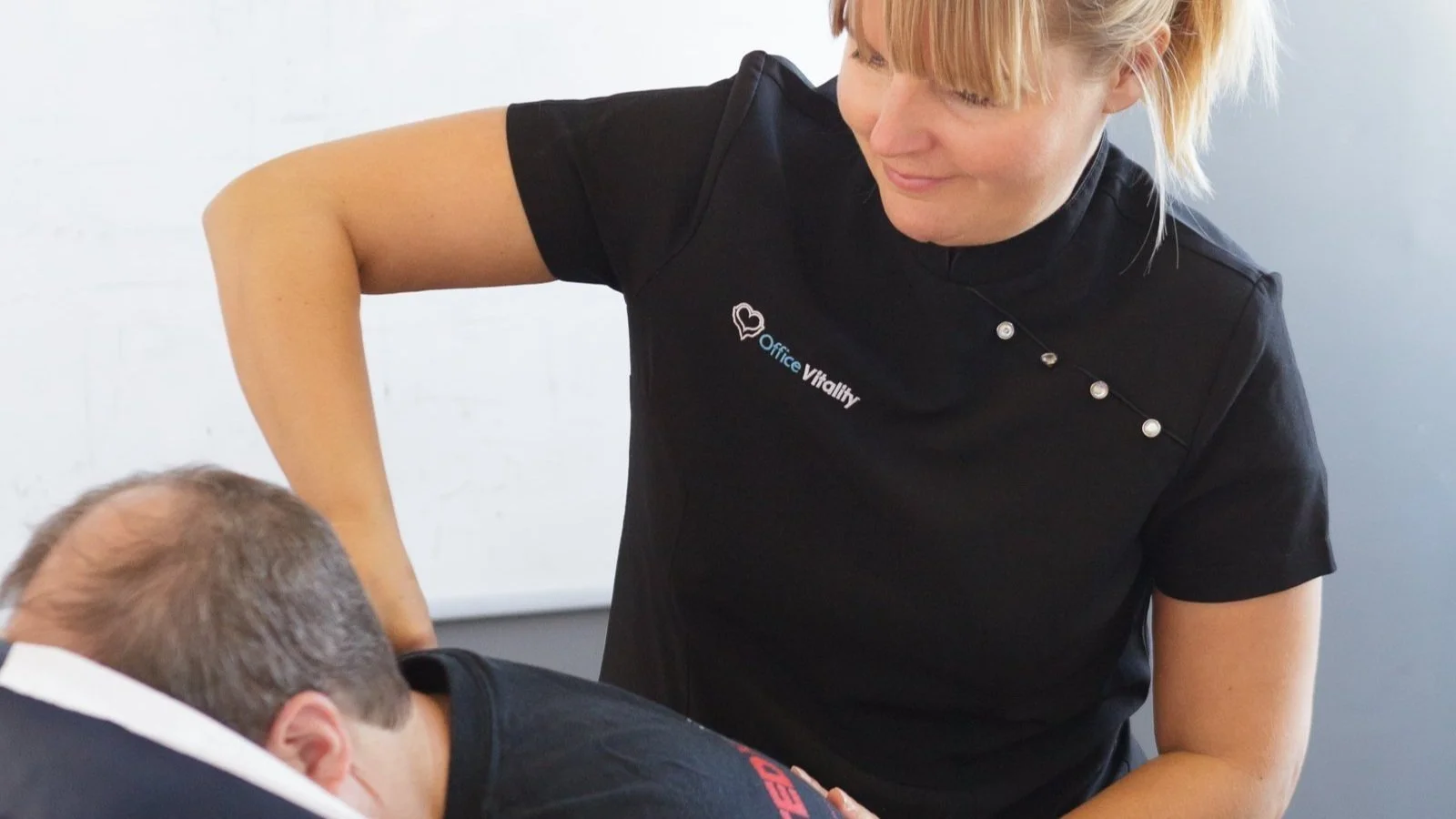 Office Vitality therapist providing on-site chair massage to a corporate client in London
