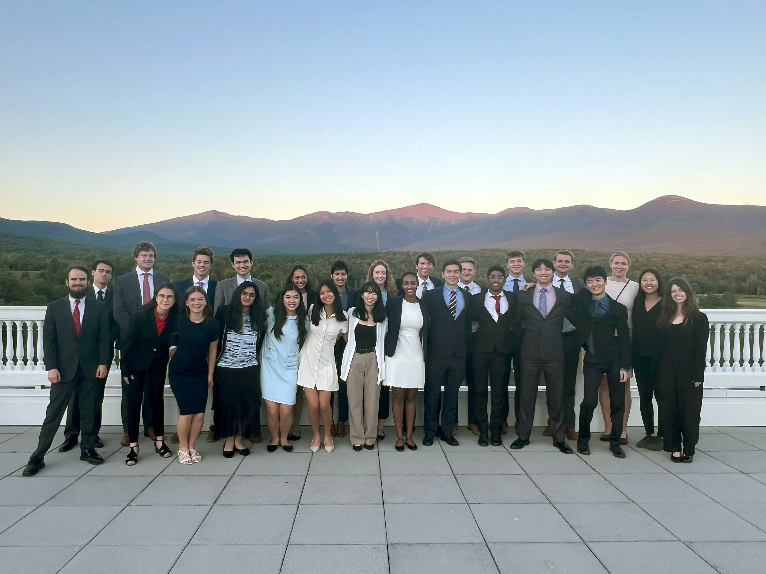 The Scholars assemble on the balcony of the Mount Washington Hotel, with the White Mountains in the background