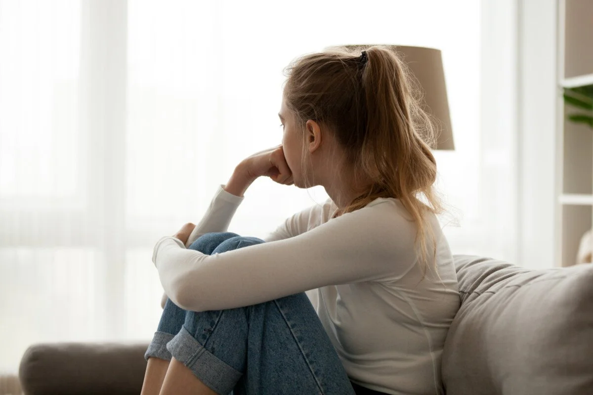 Teenage girl sitting alone appearing upset