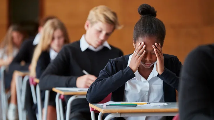 Teenage girl looking stressed in exam hall
