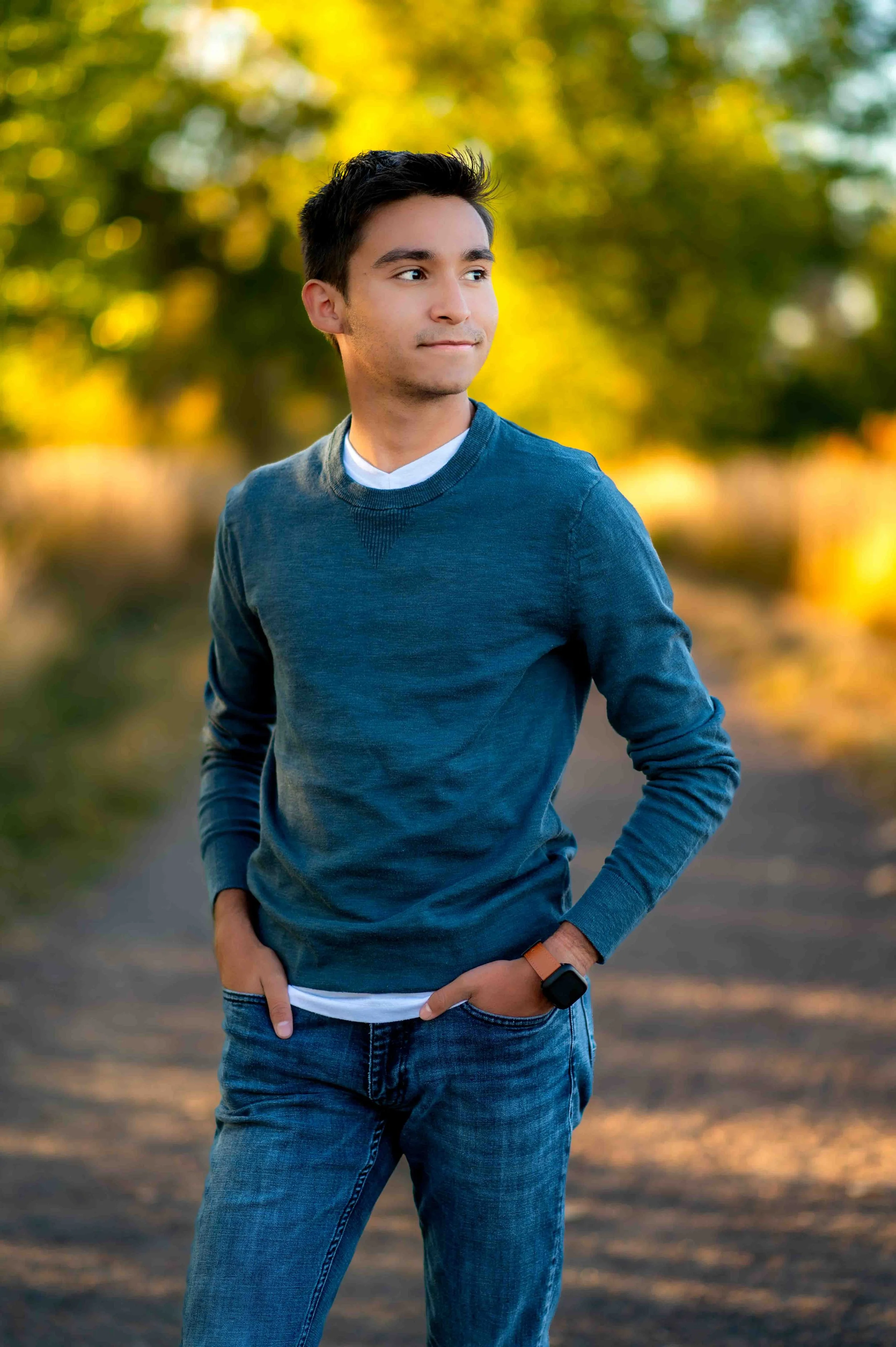 Make senior looks off to the side with hands in pocket during senior session with the Longmont School Photographer