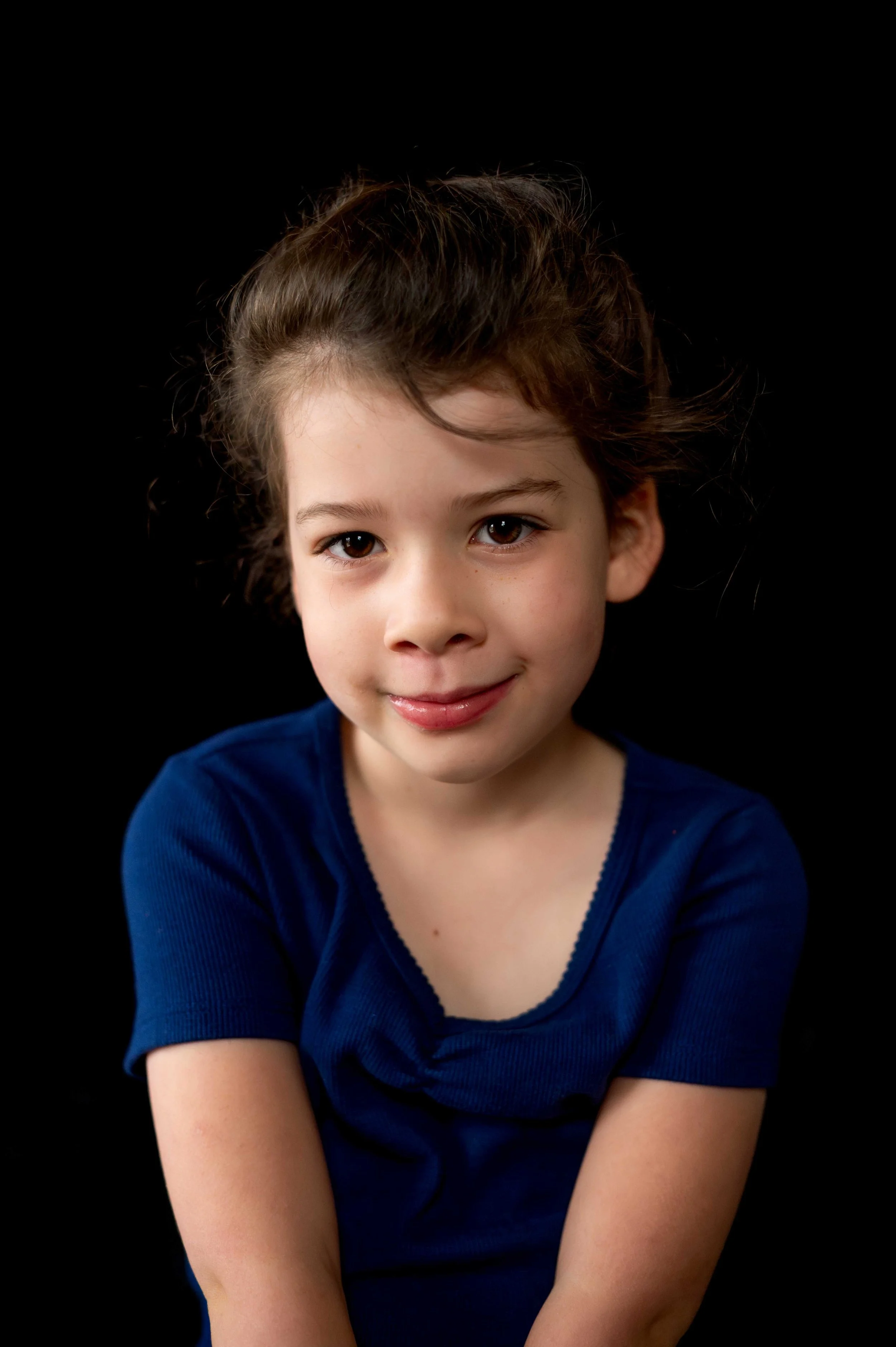 Girls looks into the camera with a soft smile during her session with the Longmont School Photographer
