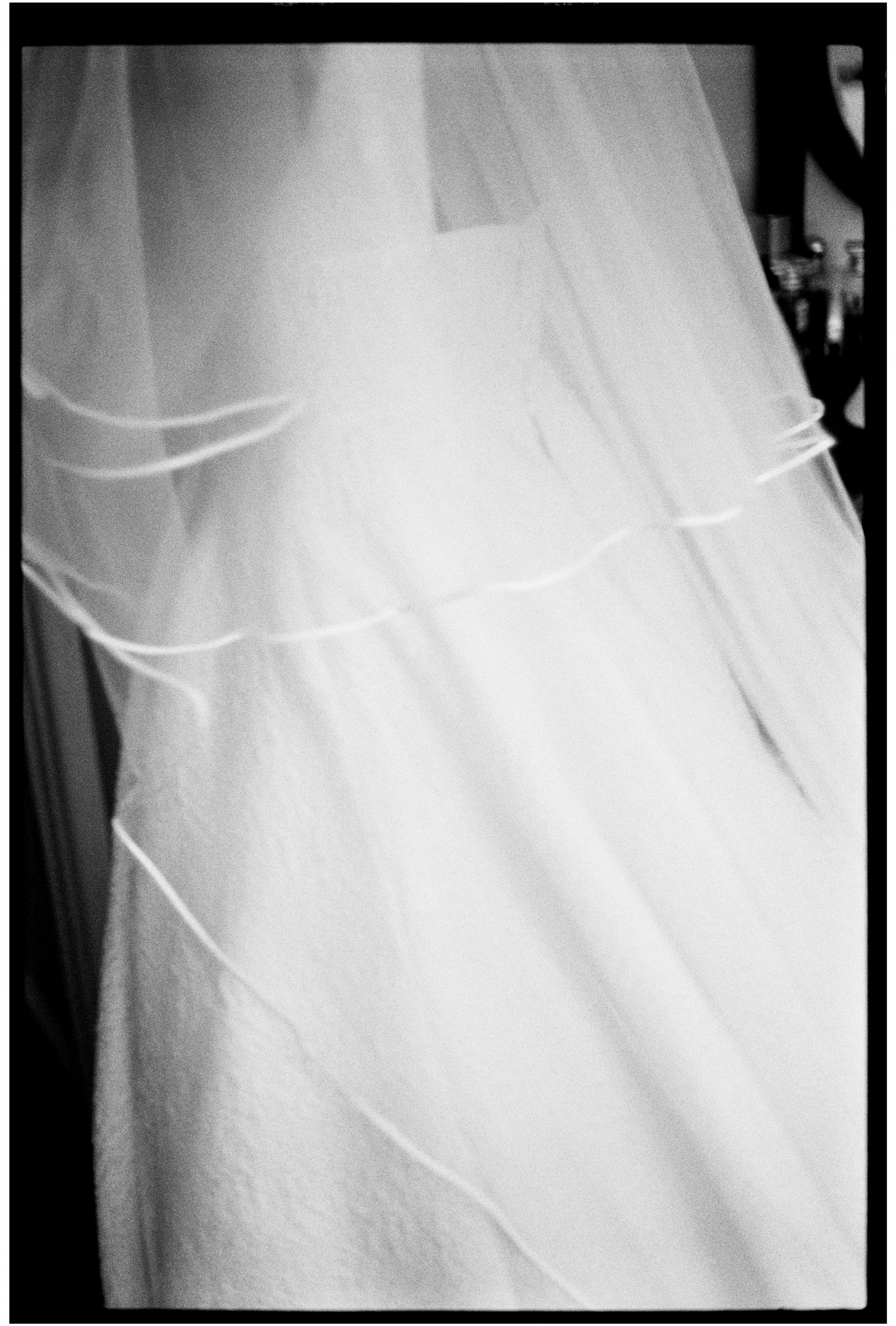 Close-up black-and-white photograph of a layered wedding veil.