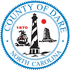 The seal of Dare County, North Carolina, featuring a lighthouse, a boat, and a bridge, with the text 'County of Dare North Carolina 1870' and a red maple leaf.