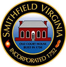 Seal of Smithfield, Virginia, featuring an old court house building with a red brick exterior, gray roof, and white windows, surrounded by text indicating the city's name, founding year 1750, and incorporation year 1752.