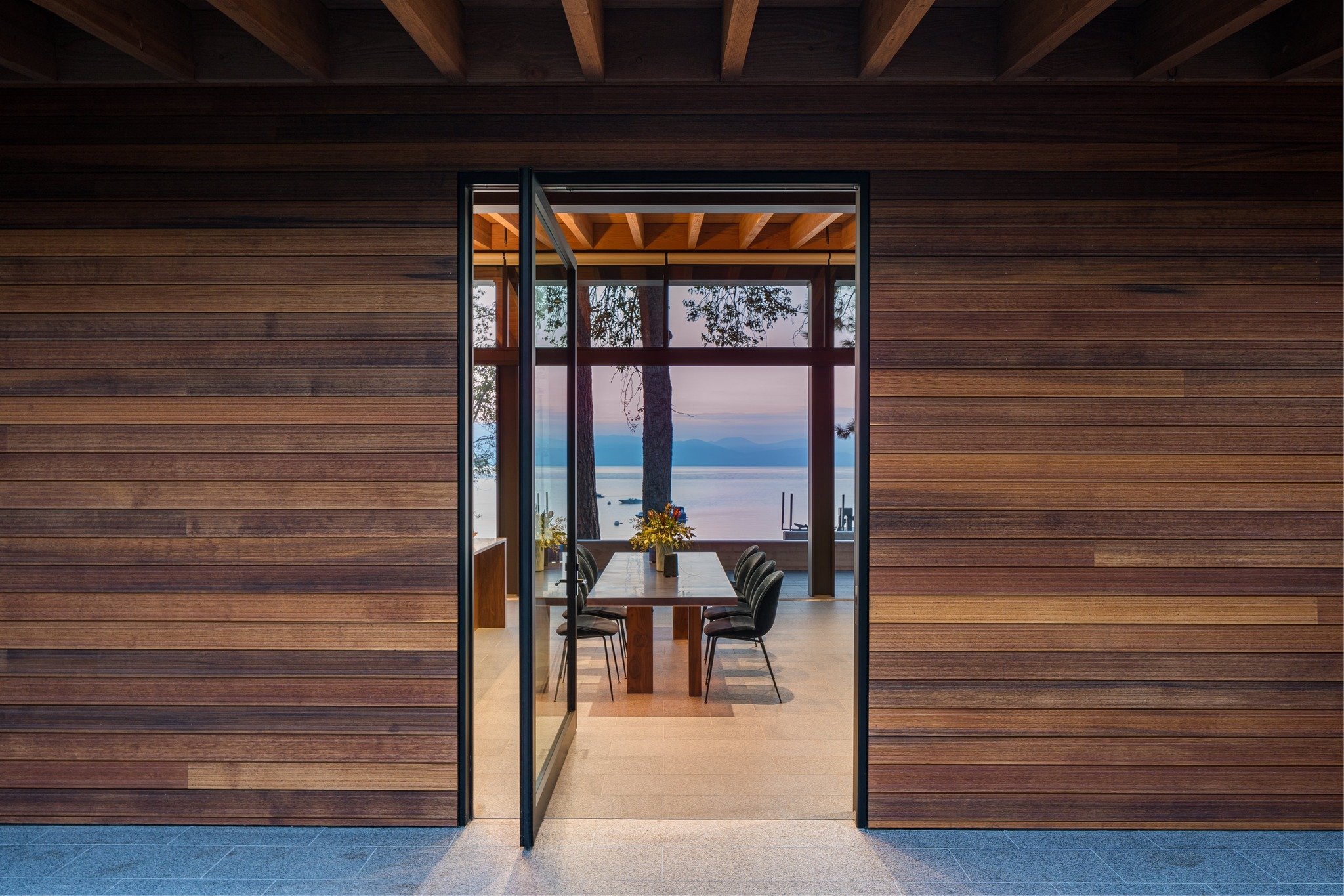 Welcome to #carnelianbay in North Tahoe. The lake views through the pivot door are breathtaking. The beautiful, yet simplistic dining room and kitchen design make way for the gorgeous natural elements of the lake and mountains beyond. #interiordesign