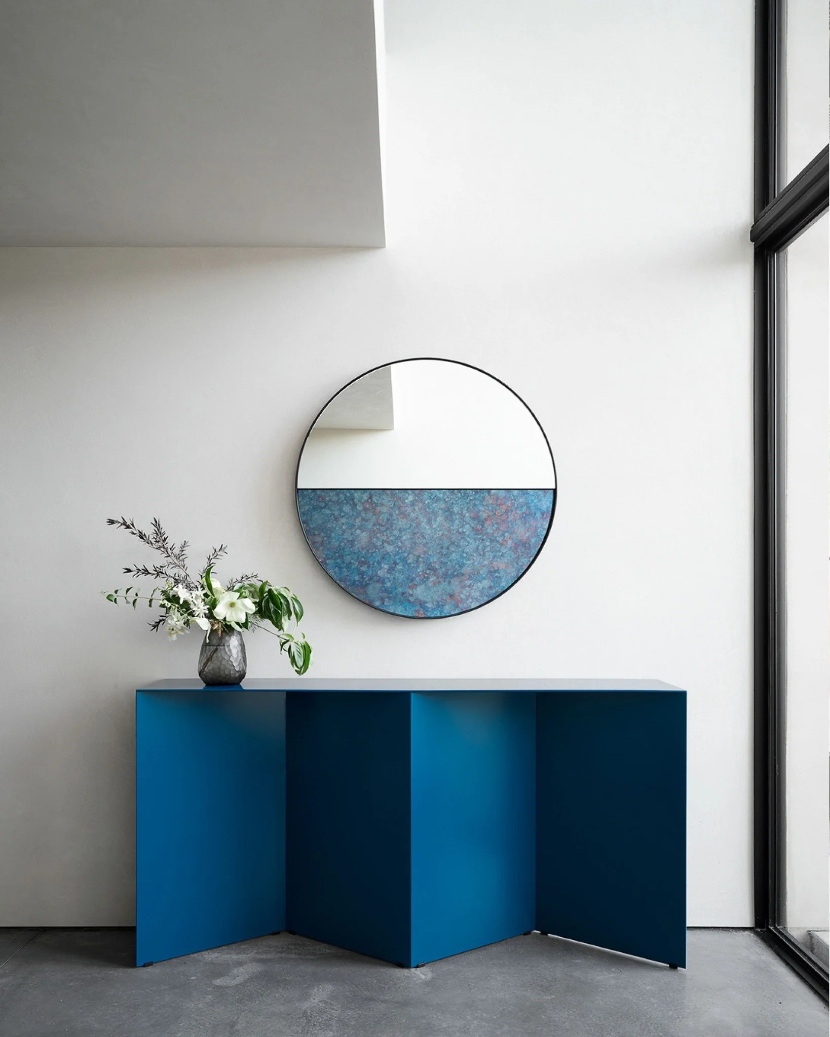 In the quieter moments, form and material take center stage. This sculptural console, paired with a circular art mirror, creates a serene vignette where geometry, color, and light meet.

#NapaValleyDesign #ModernInteriors #ArchitectureAndArt #Califor