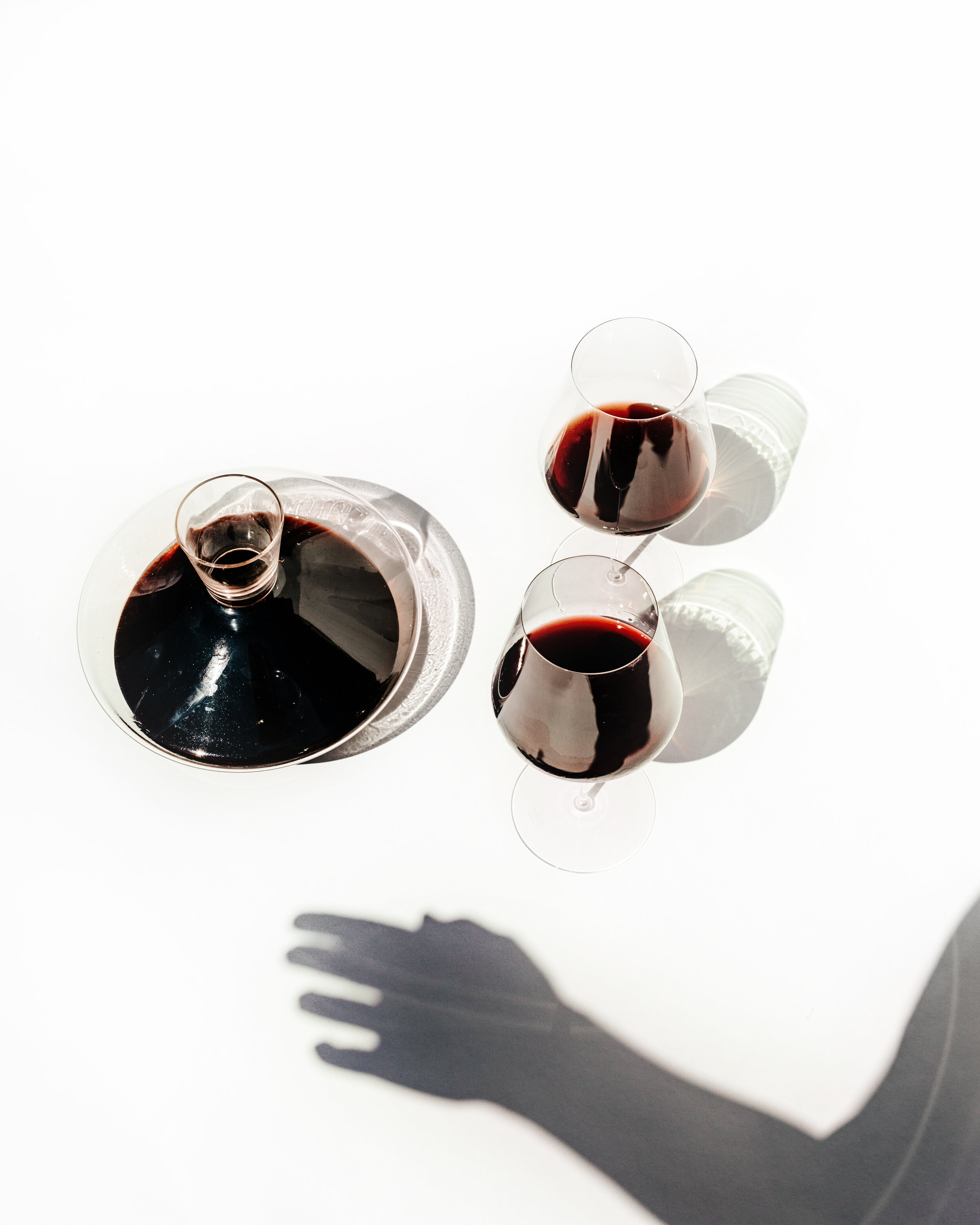 silhouette of a woman's hand with wine decanter