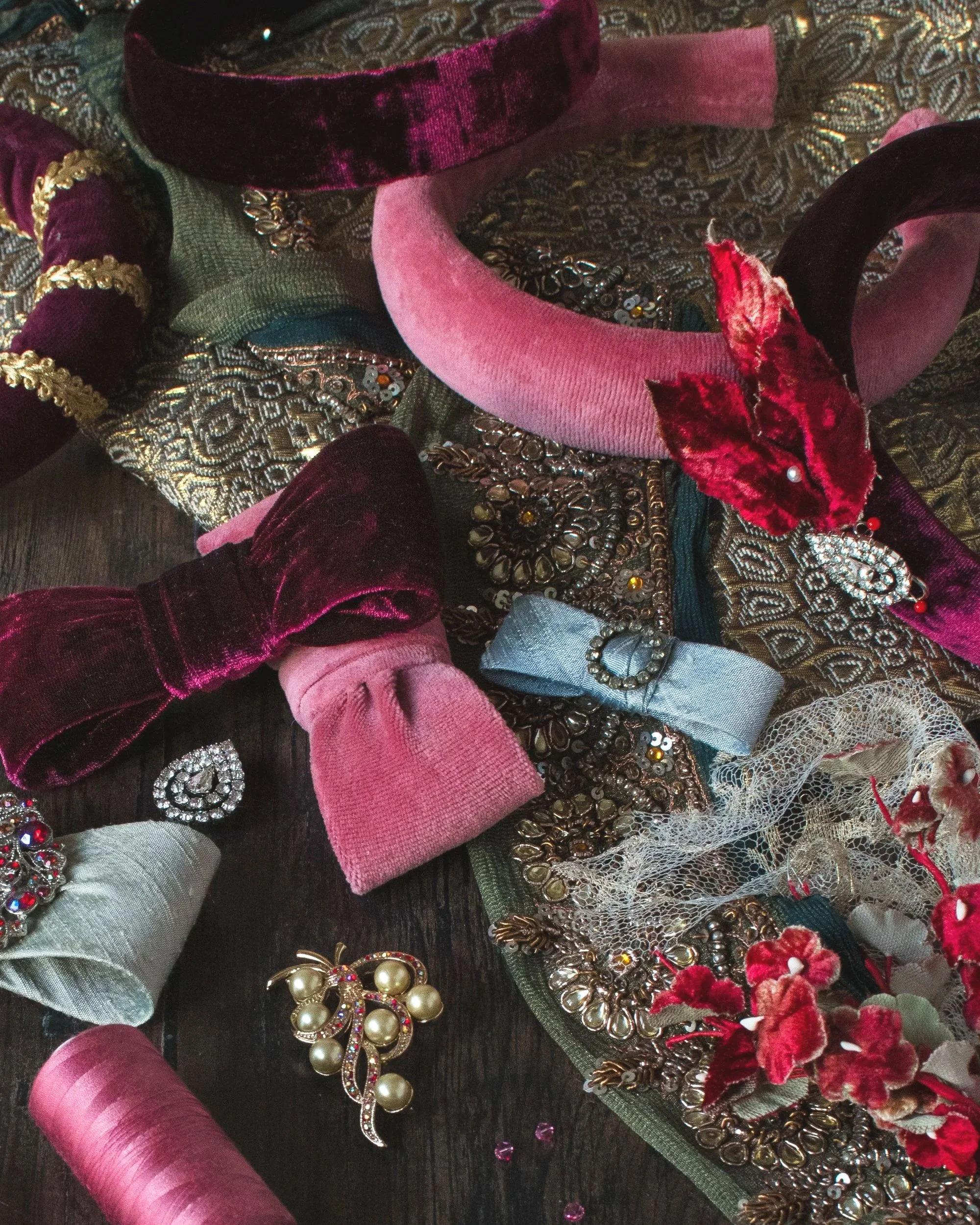 A messy tabletop filled with couture bows and padded headbands