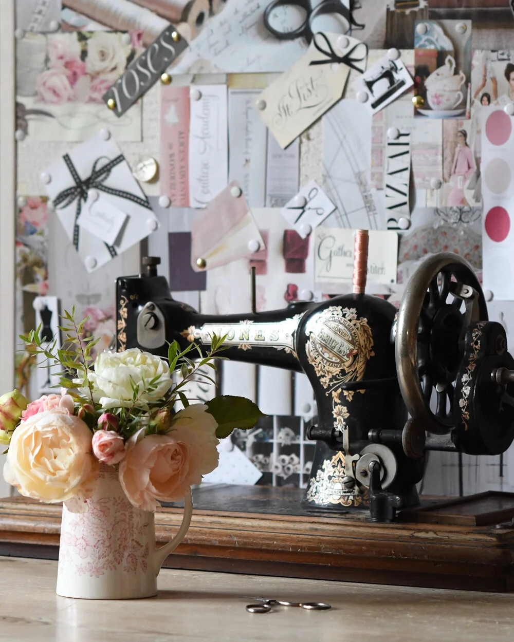 Vintage sewing machine, garden roses in a china jug and a brand board for To Gather And Stitch