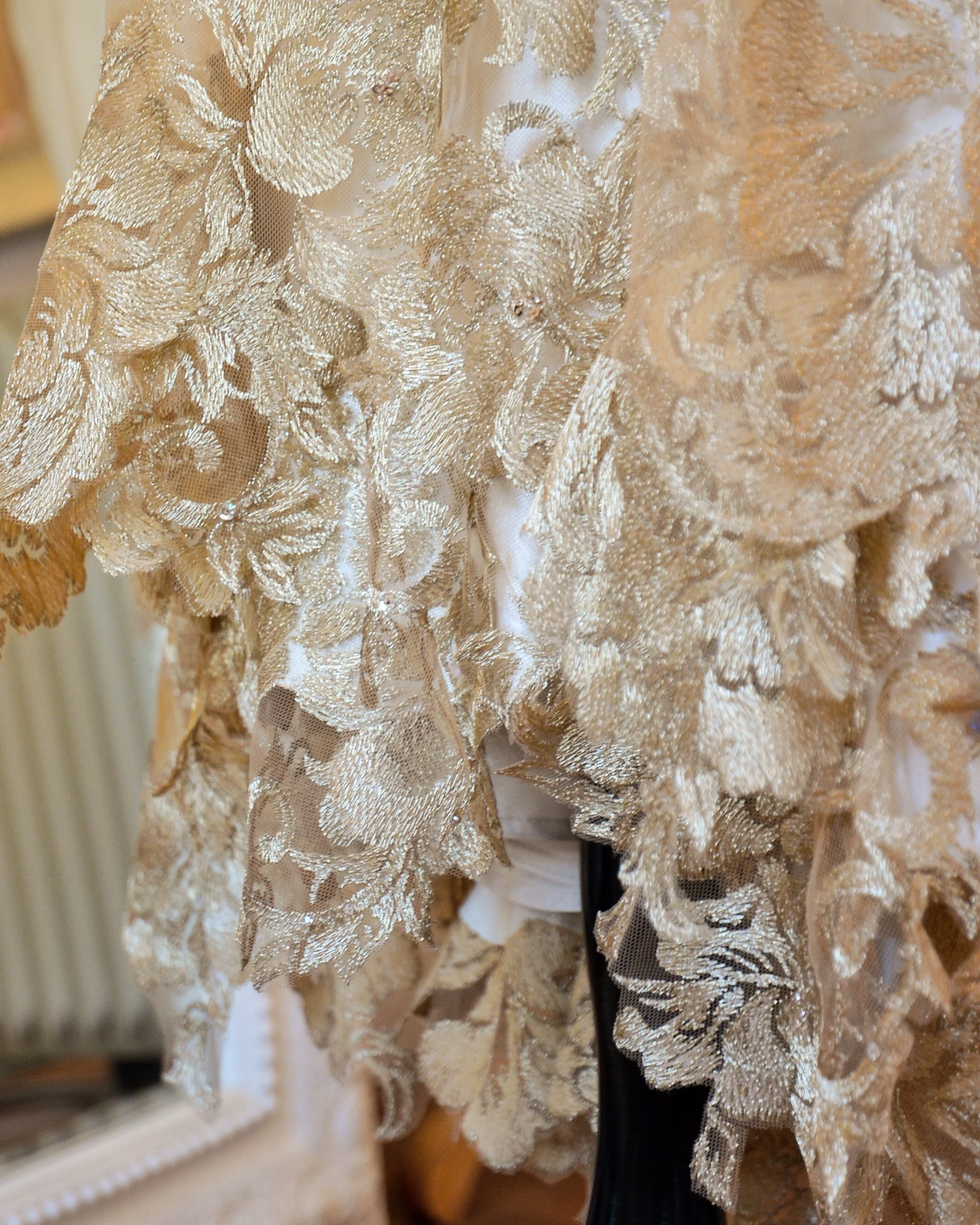 A gold lace dress on a  mannequin