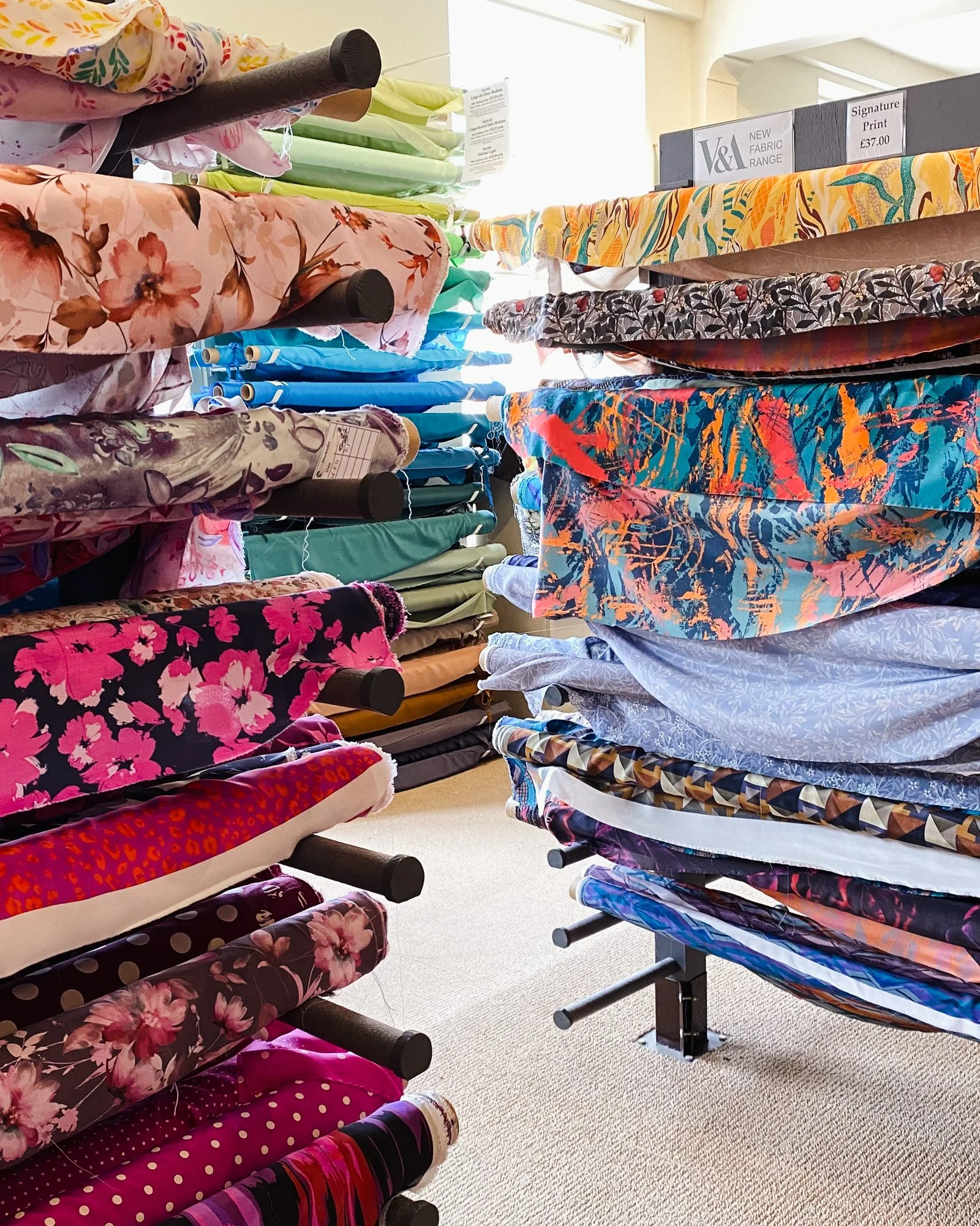 Rolls of printed silks in a rainbow of colours at Beckford Silk
