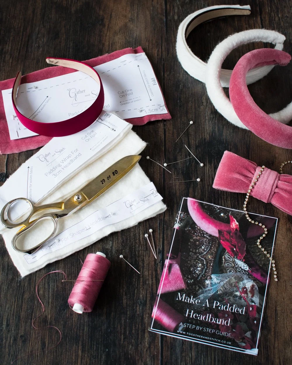 A sewing kit for a handmade padded headband embellished with a couture bow on a dark tabletop, featuring illustrated instructions and a paper pattern